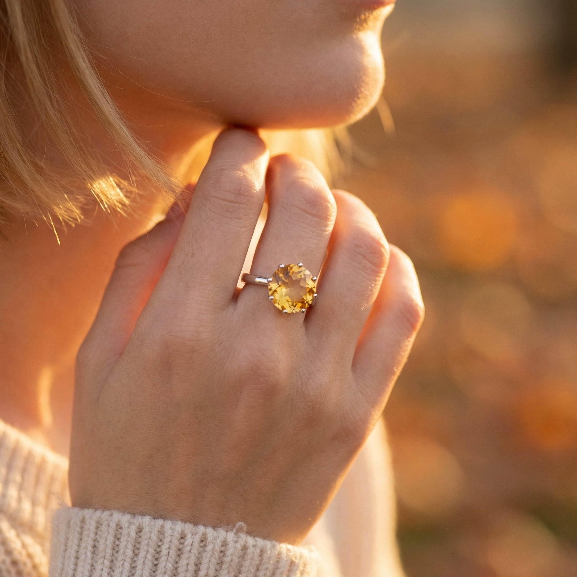 Woman wearing the Phaenna citrine ring in sterling silver, showcasing the large round-cut gemstone on her finger.