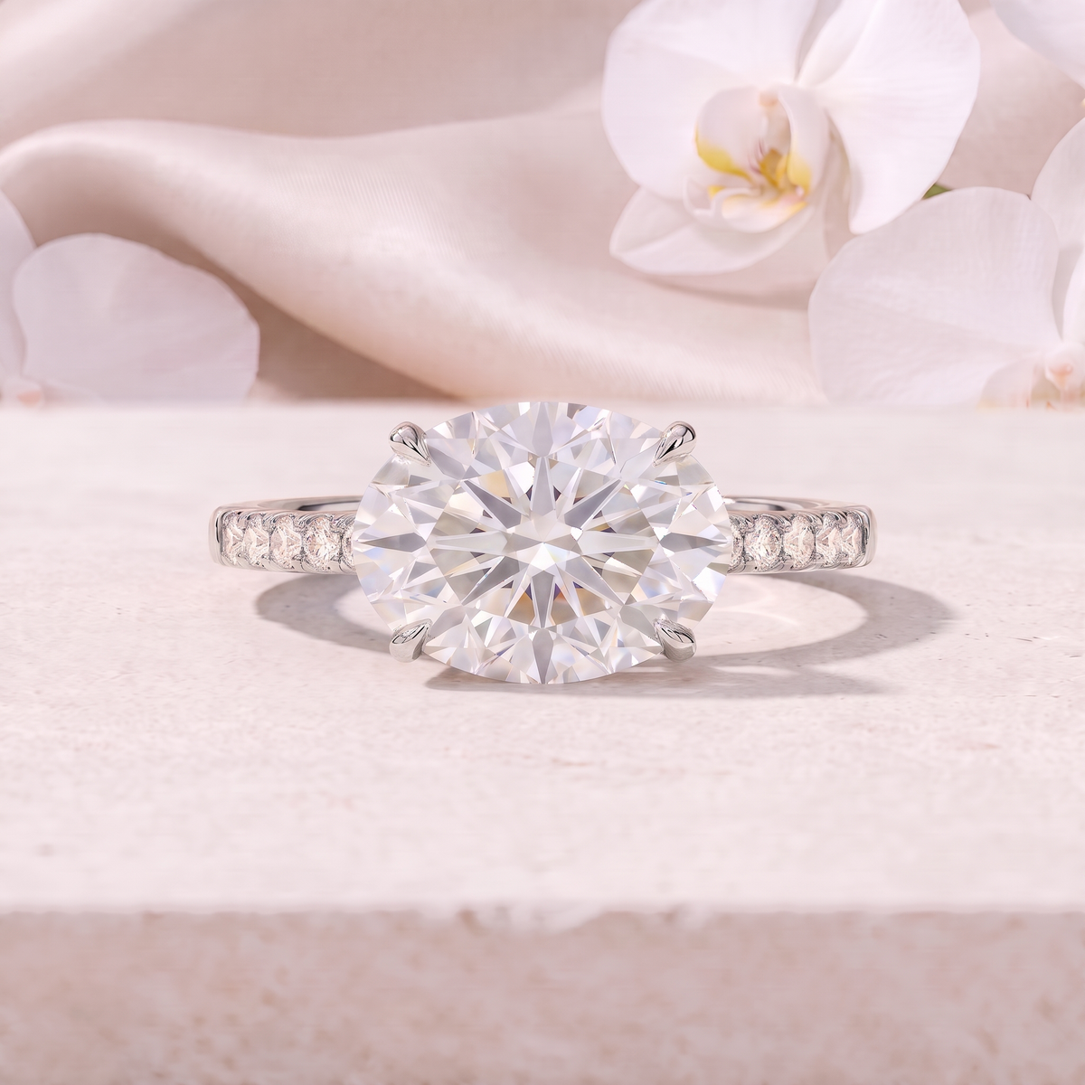 An East-West oval cut moissanite engagement ring featuring a pavé band in white gold.