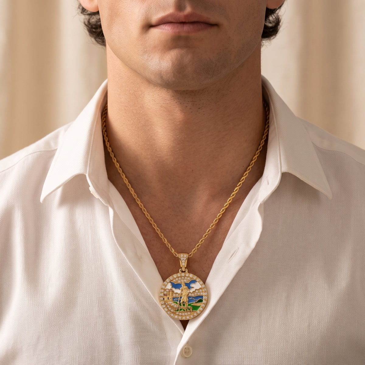 Frontal view of a man wearing the round gold-tone enamel medallion necklace over a white collared shirt.