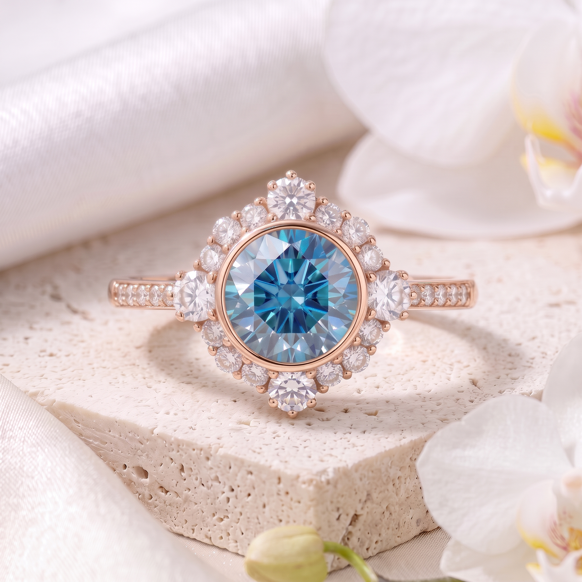 Front view of a round blue moissanite vintage halo engagement ring in rose gold on a stone block.