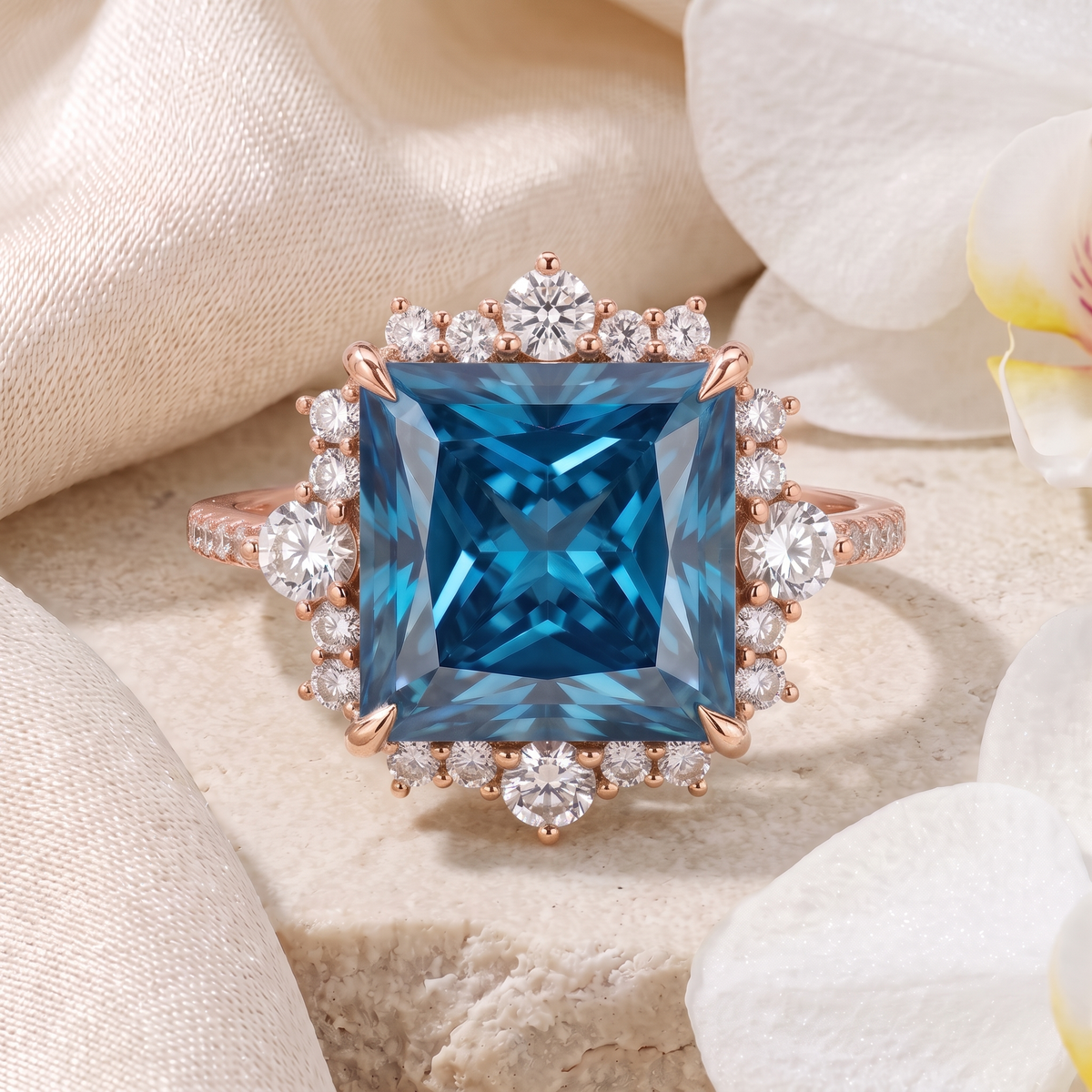 Front view of a rose gold princess-cut blue moissanite halo engagement ring on textured stone.