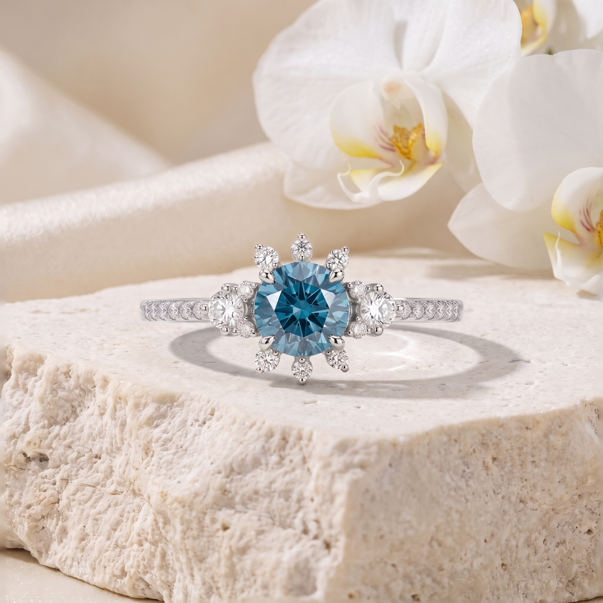 White gold moissanite ring featuring a round blue center gemstone surrounded by a diamond starburst halo.