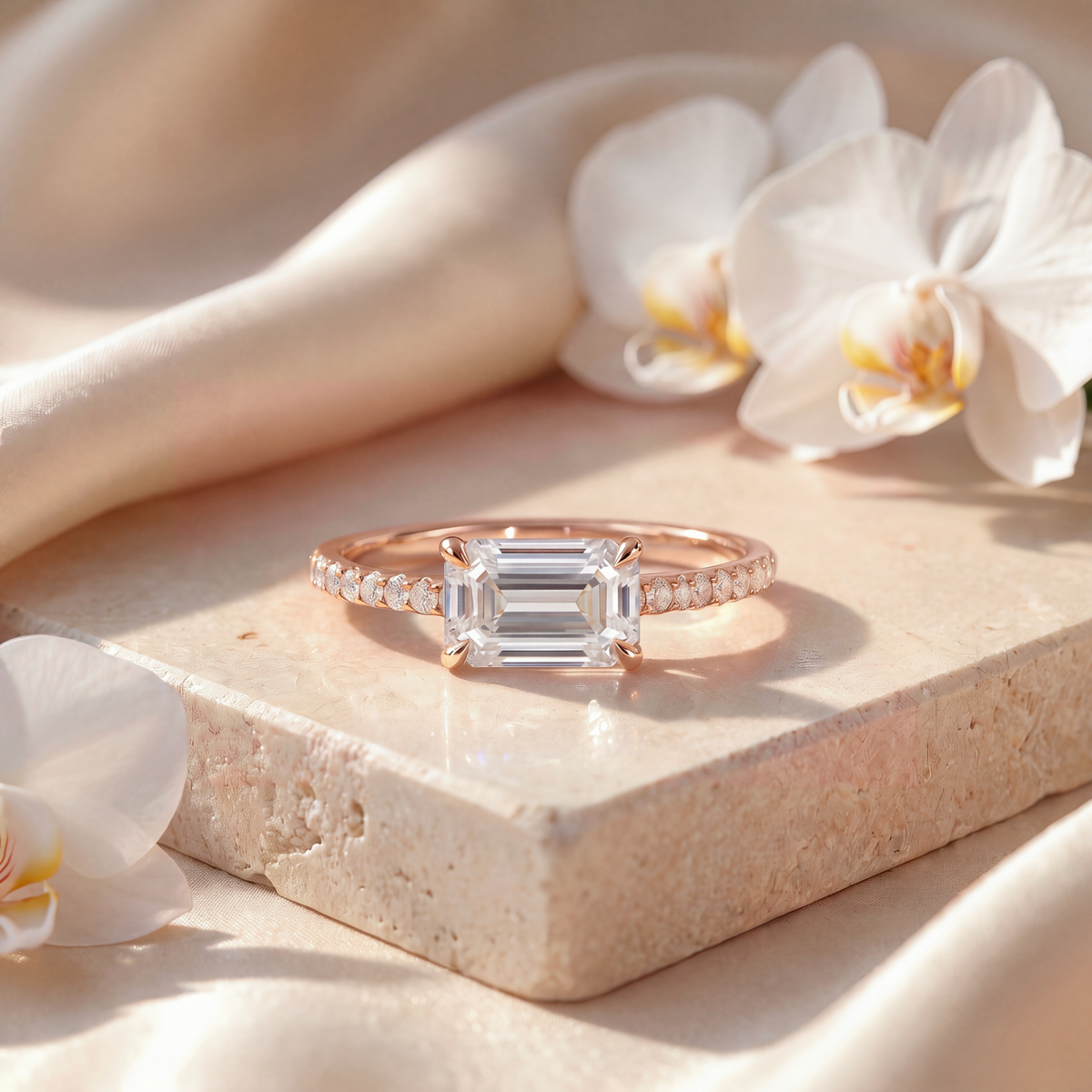 Rose gold engagement ring featuring an east-west emerald-cut moissanite stone and pavé accents.
