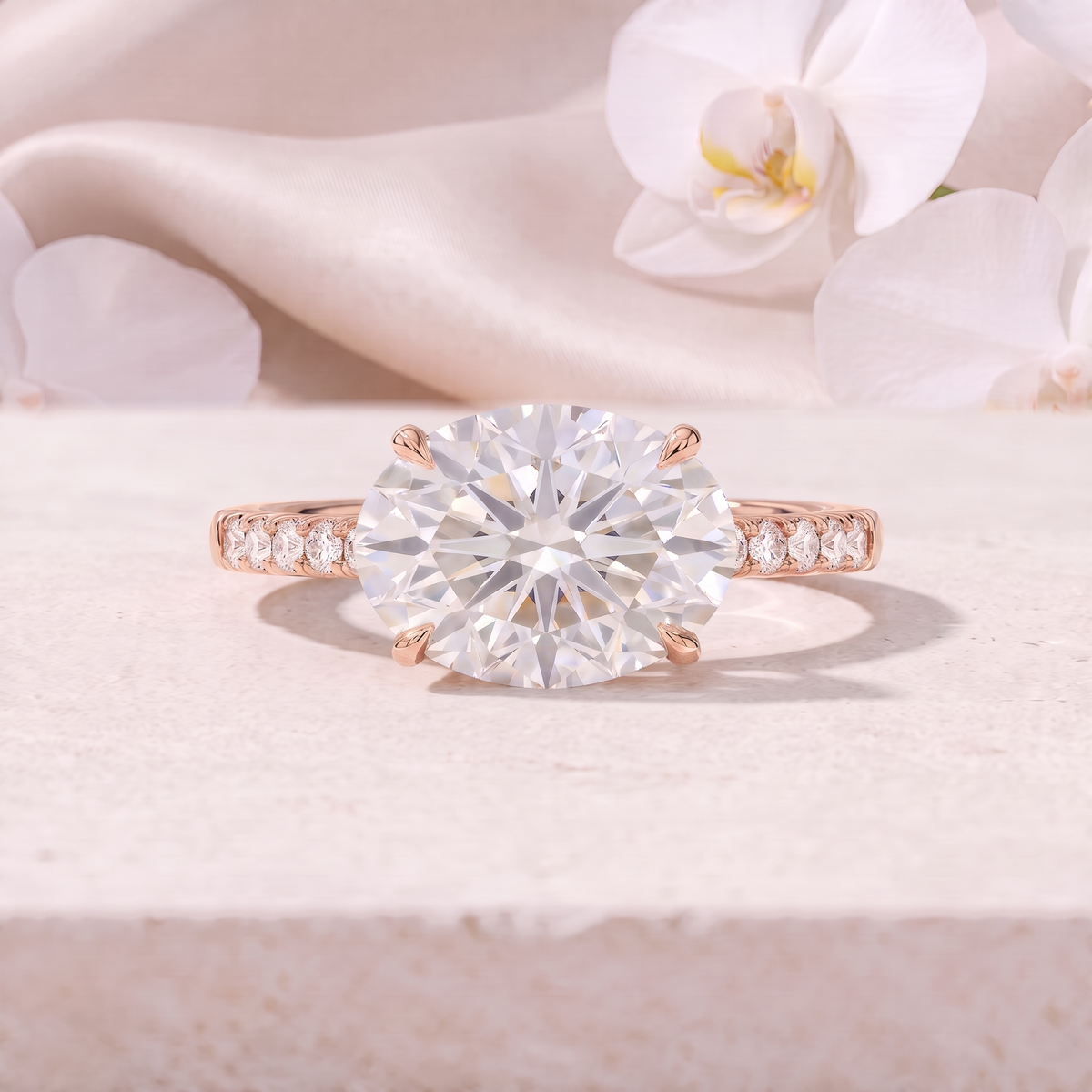 An East-West oval cut moissanite engagement ring featuring a pavé band in rose gold.
