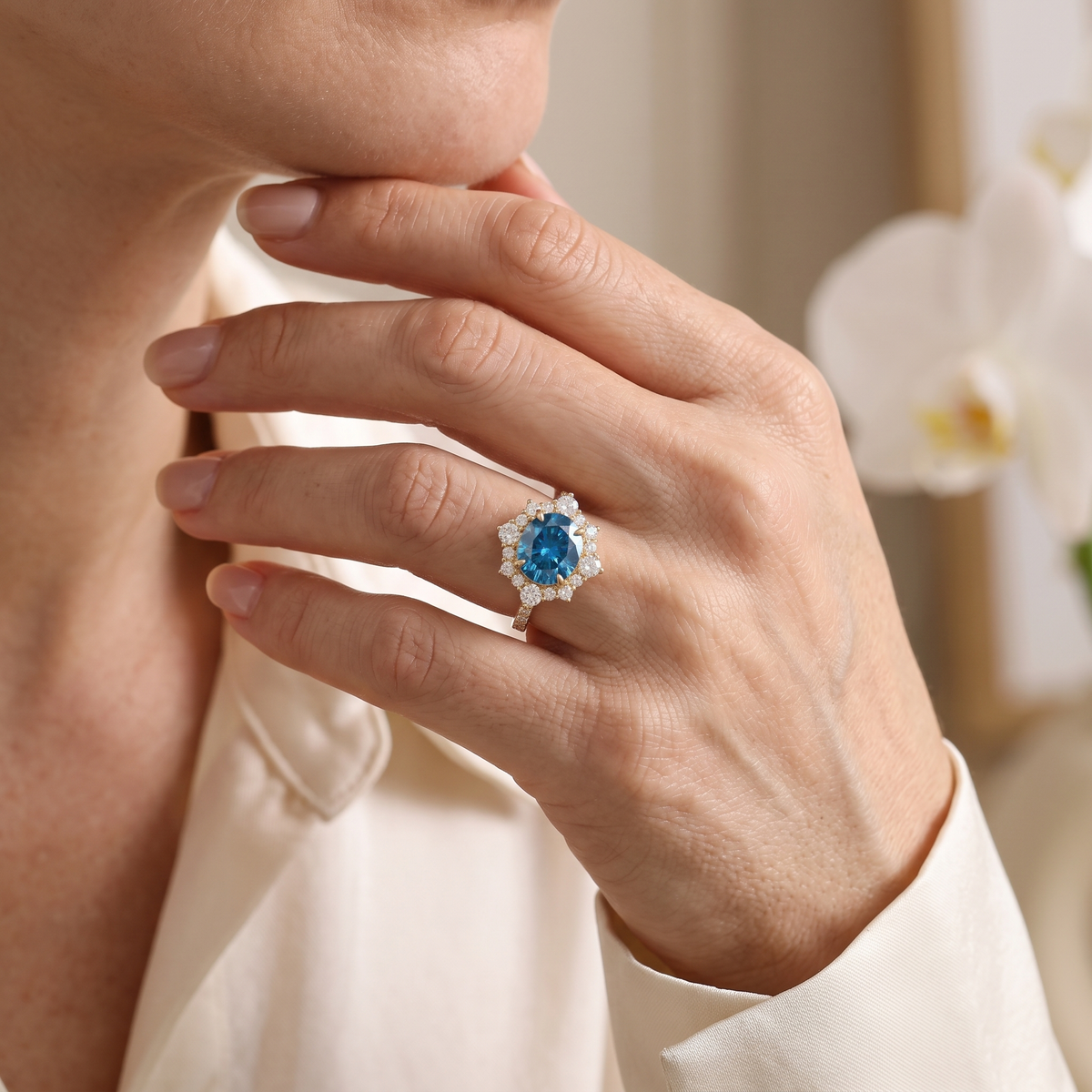 Close-up lifestyle view of a model wearing the rose gold oval blue moissanite halo ring.