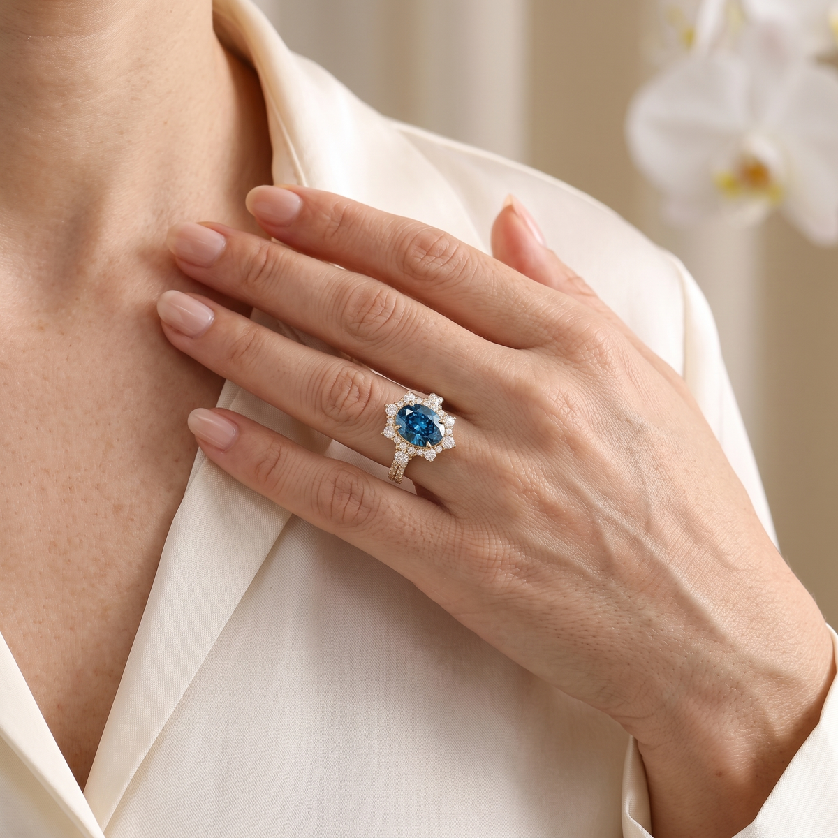 Lifestyle view of the rose gold oval blue moissanite halo engagement ring worn on a hand.