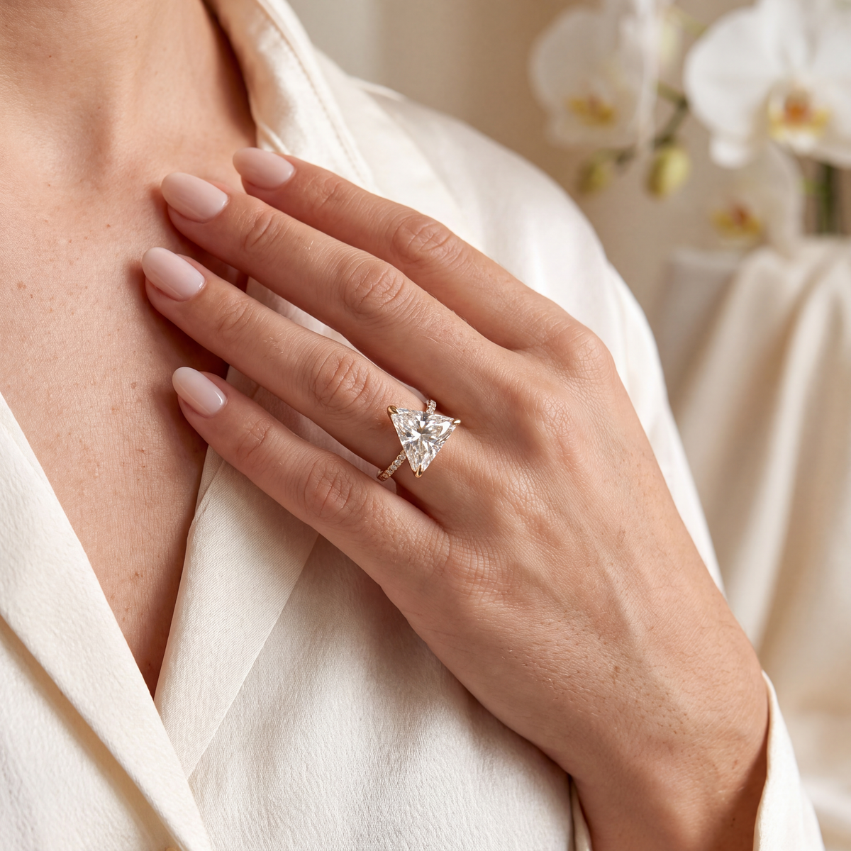 Close-up lifestyle view of a model wearing the yellow gold trillion-cut moissanite ring.