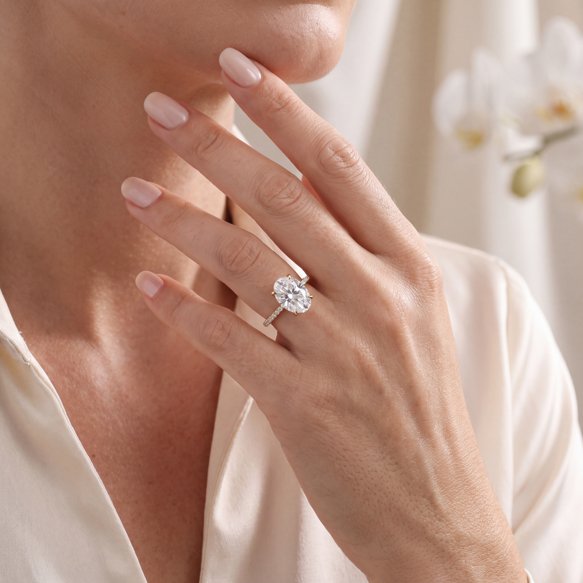 Close-up shot of a model wearing the yellow gold oval moissanite engagement ring.