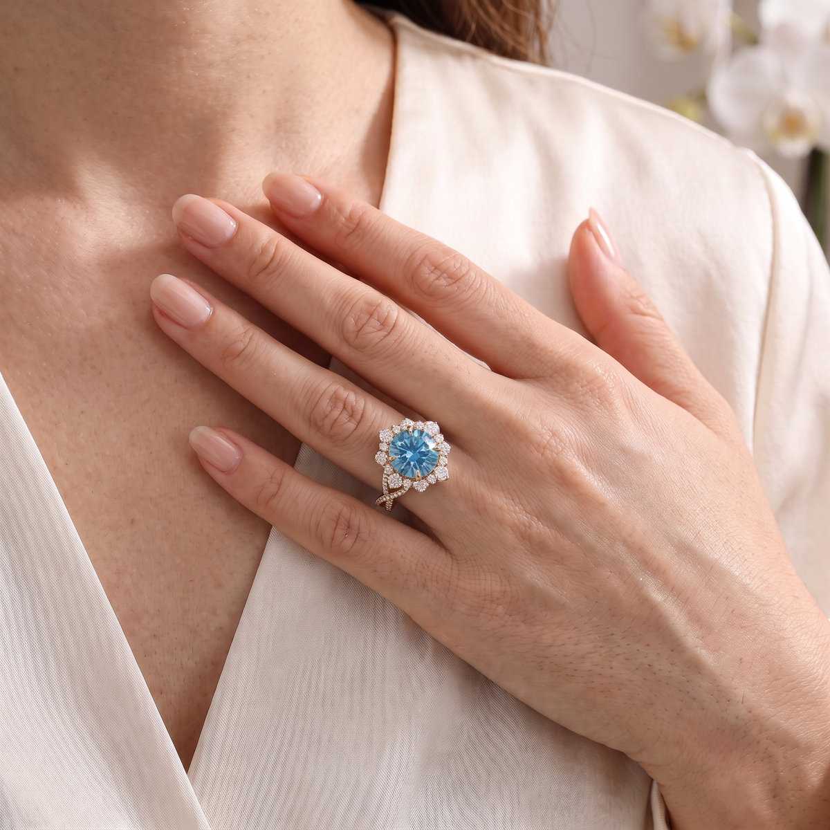 A woman posing with a rose gold blue moissanite halo ring worn on her hand.