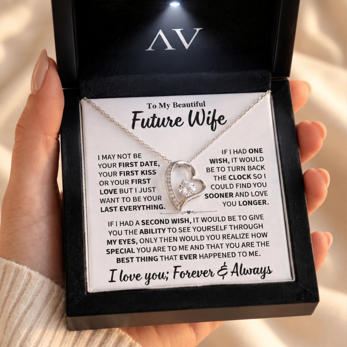 Heart necklace and To My Future Wife card in a handheld black gift box under warm lighting.