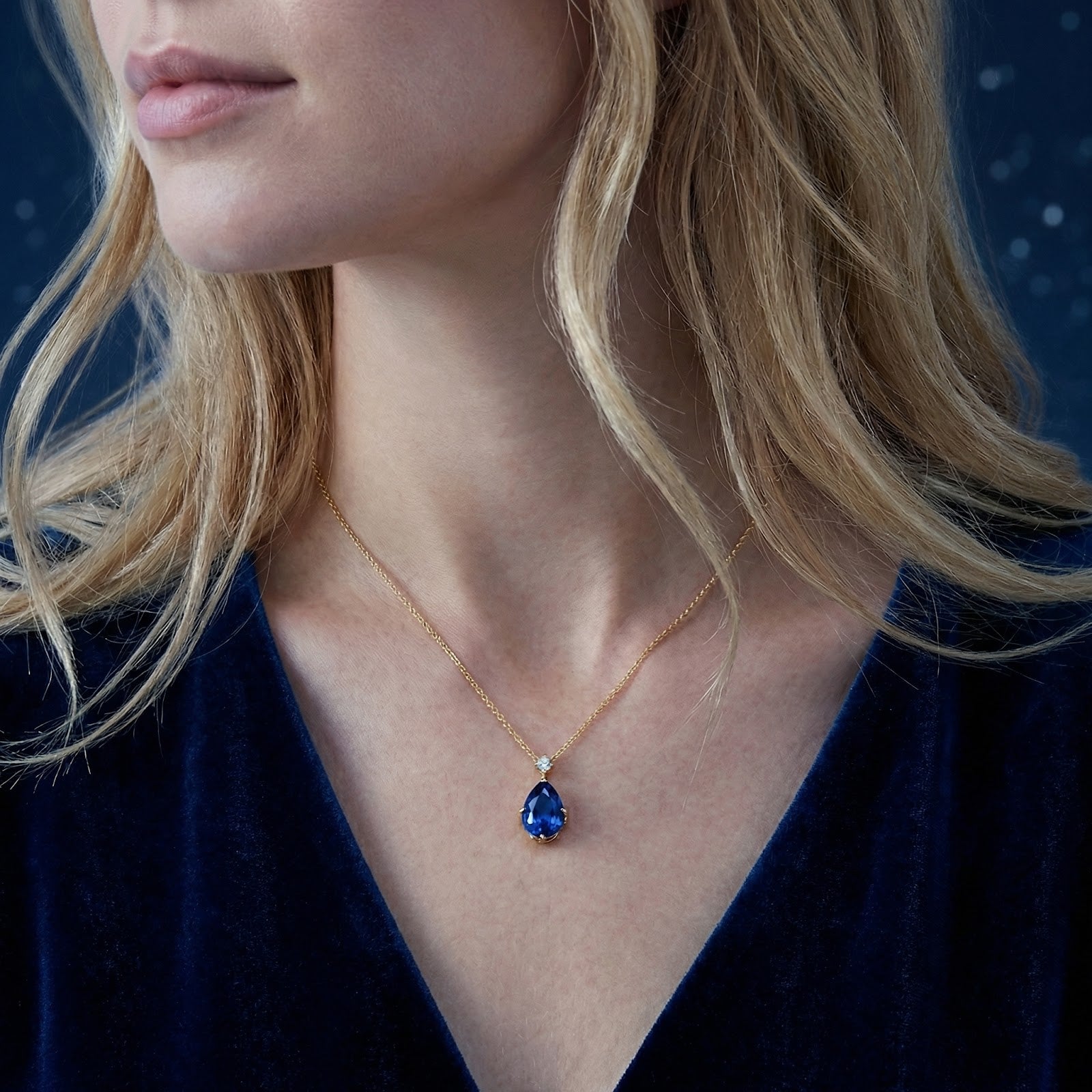 Close-up of a model wearing the Mariselle pear-cut simulated sapphire necklace in 18K gold vermeil.