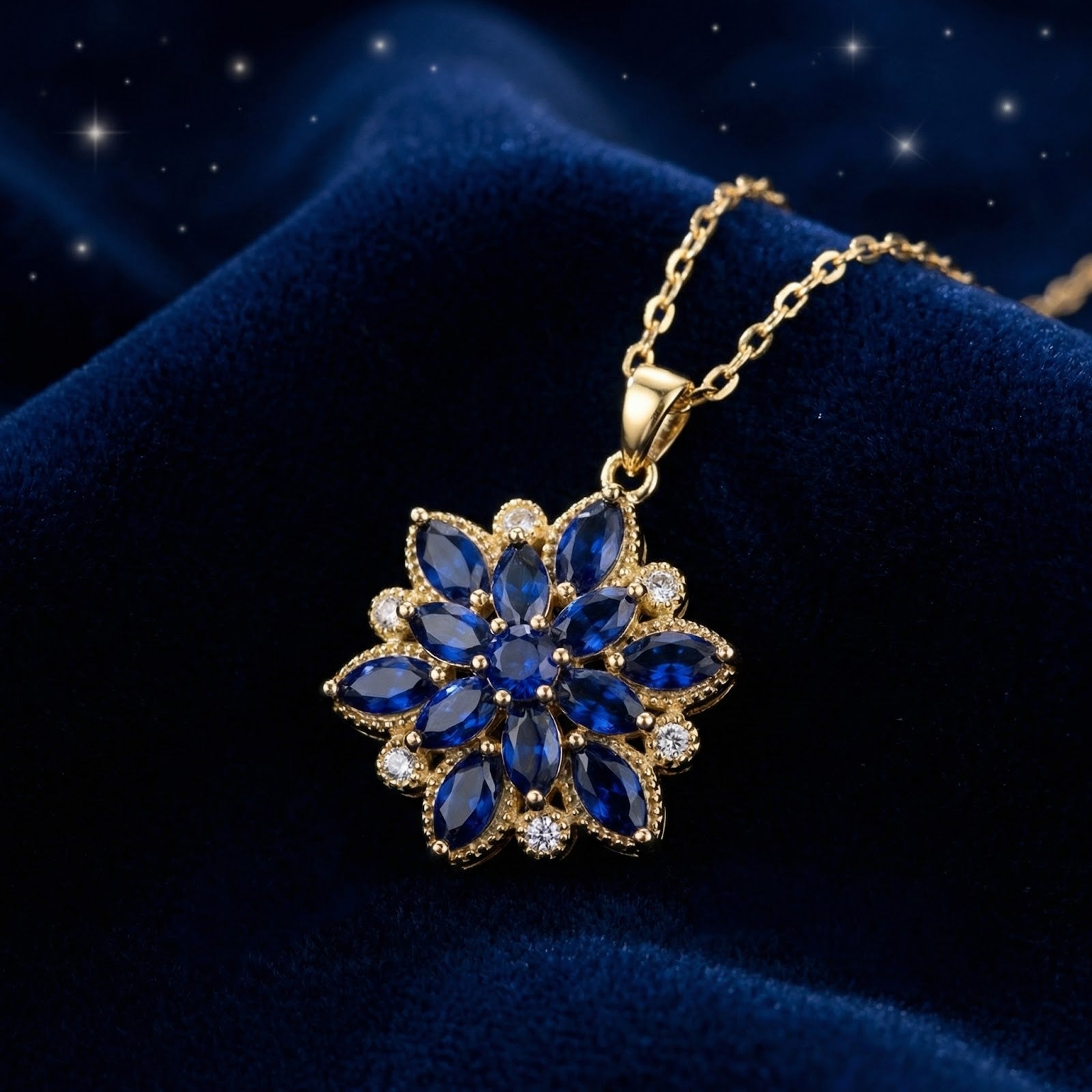 Gold finish floral pendant with marquise and round cut blue simulated sapphires on blue velvet.