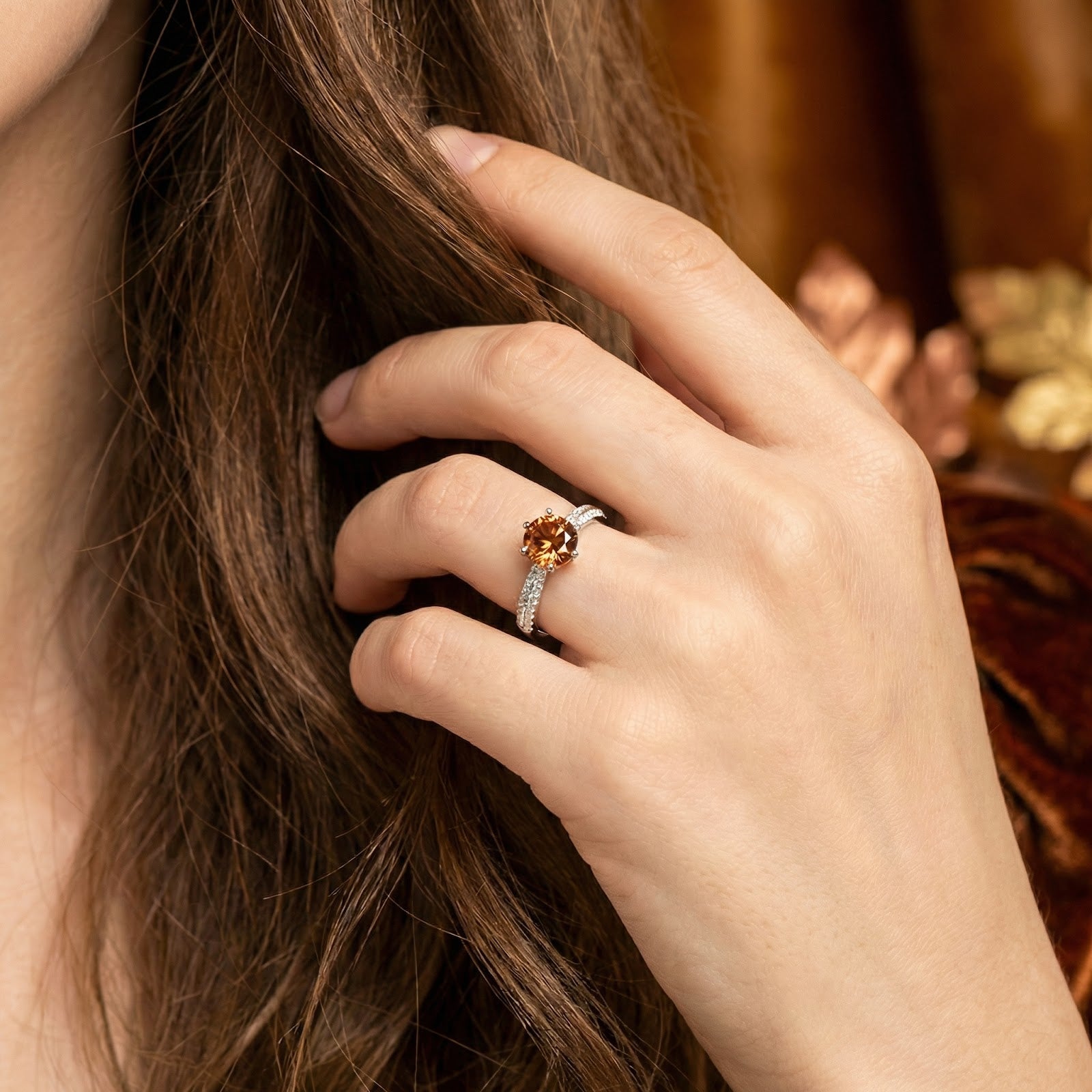 Honey-colored round simulated topaz ring in sterling silver worn on a woman's hand in a lifestyle setting.