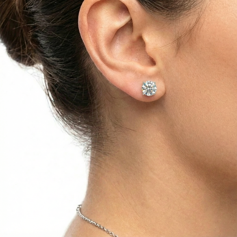 Close-up of a woman wearing a round-cut simulated diamond stud earring in sterling silver.