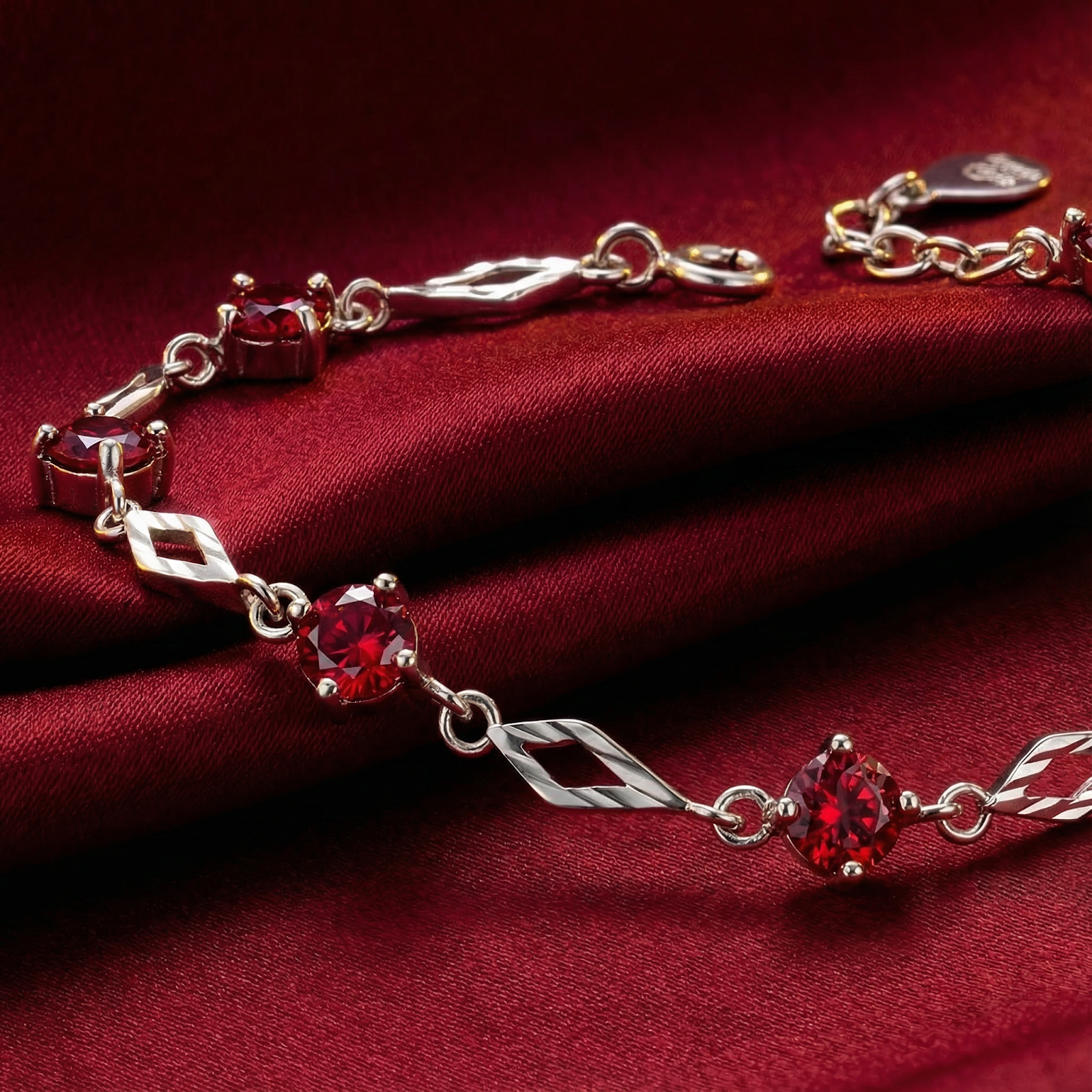 Close-up of S925 sterling silver station bracelet showing round-cut simulated rubies and textured diamond links.