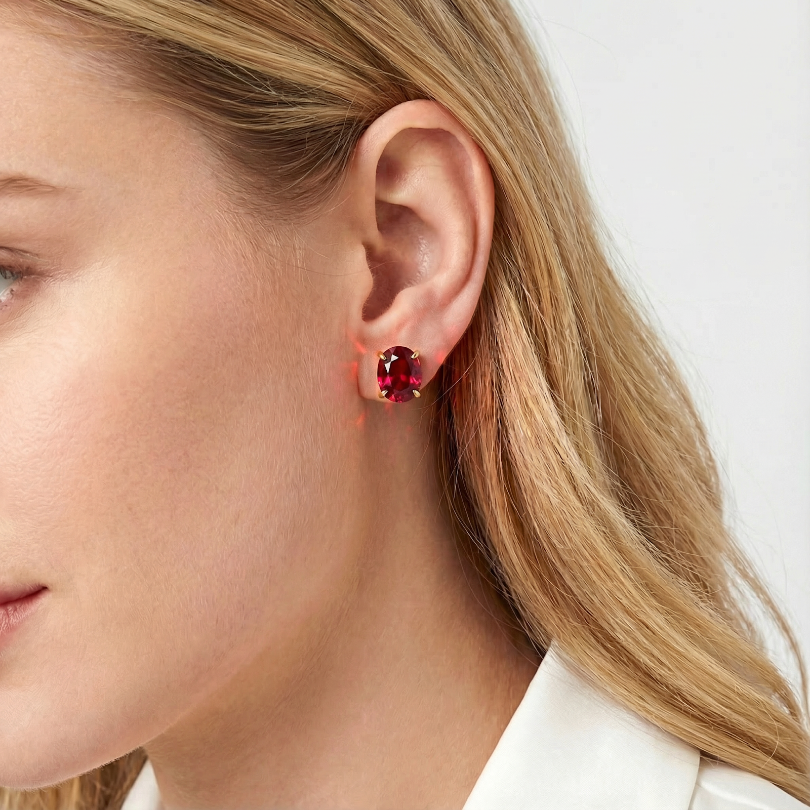 Close-up of a model wearing the Rubina stud earring, highlighting the 18K gold vermeil and red simulated ruby.