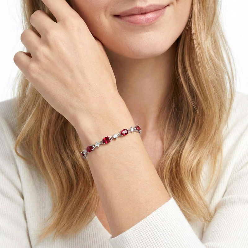 Woman wearing the sterling silver and oval simulated ruby station bracelet, showing its fit and style.