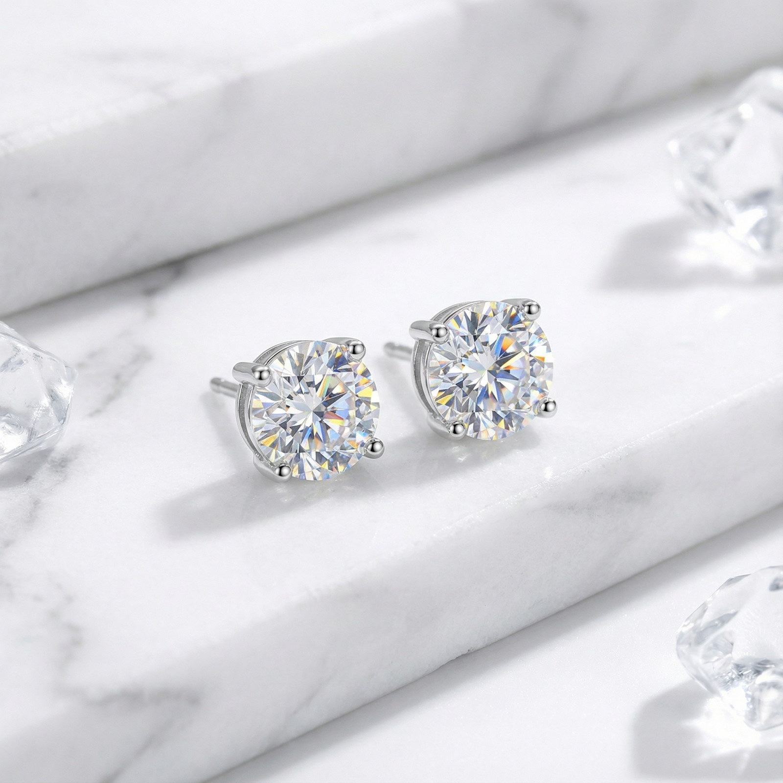 Pair of round-cut A5 Zirconia studs in sterling silver settings displayed on a white marble background.