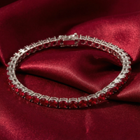 Adalira July birthstone tennis bracelet with round simulated rubies on a red satin fabric background.