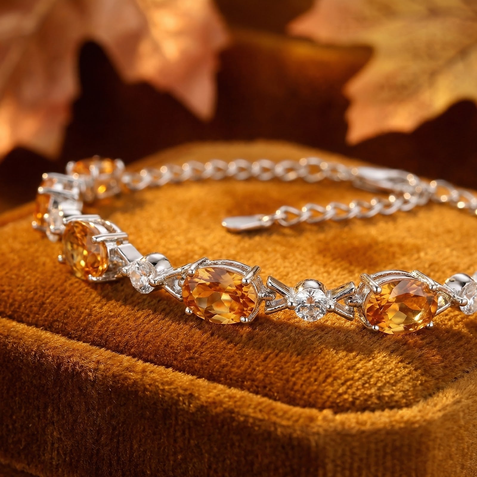 Close-up of oval-cut simulated topaz stones in a sterling silver station bracelet setting.