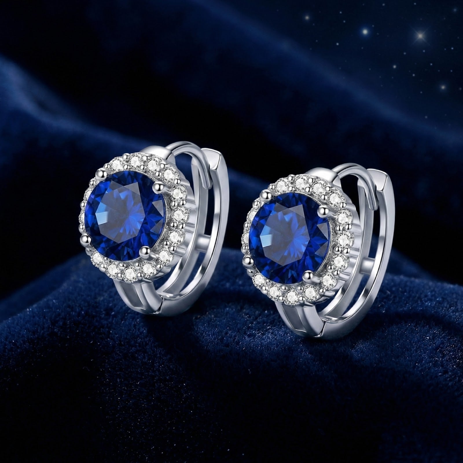 Close-up of round blue moissanite halo earrings in sterling silver showing the setting and hinged back closure.