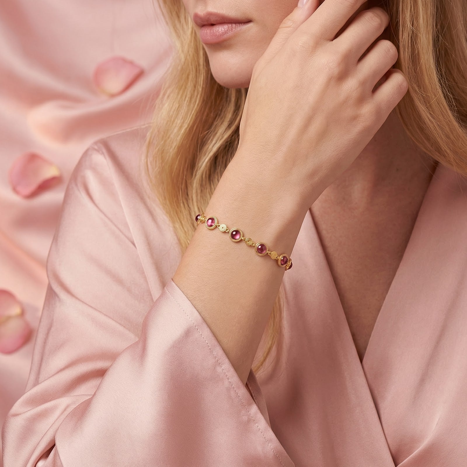 Lifestyle shot of a woman wearing the pink tourmaline and gold vermeil station bracelet with a pink silk robe.