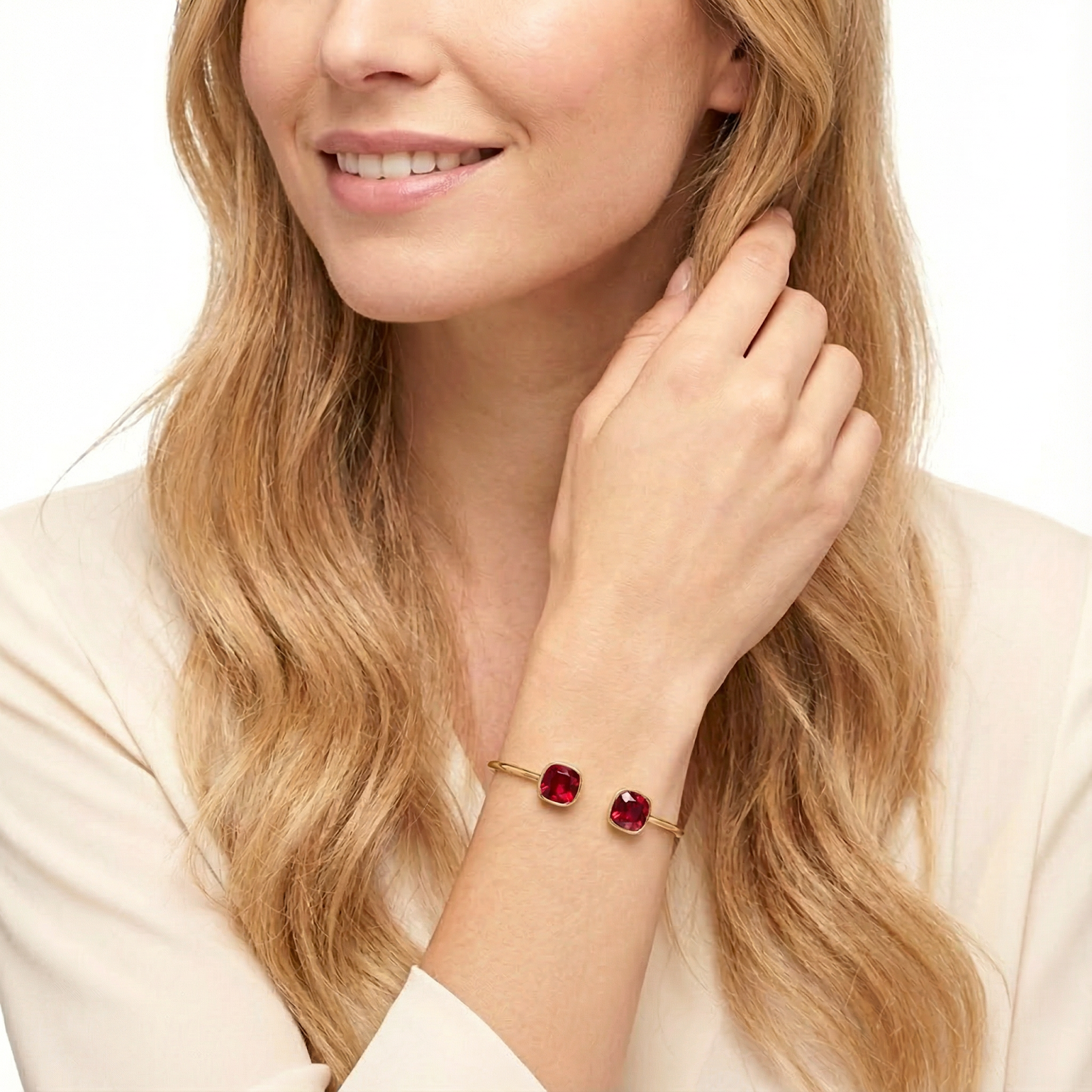 Gold-tone stainless steel cuff bracelet with red simulated rubies worn on a model's wrist.