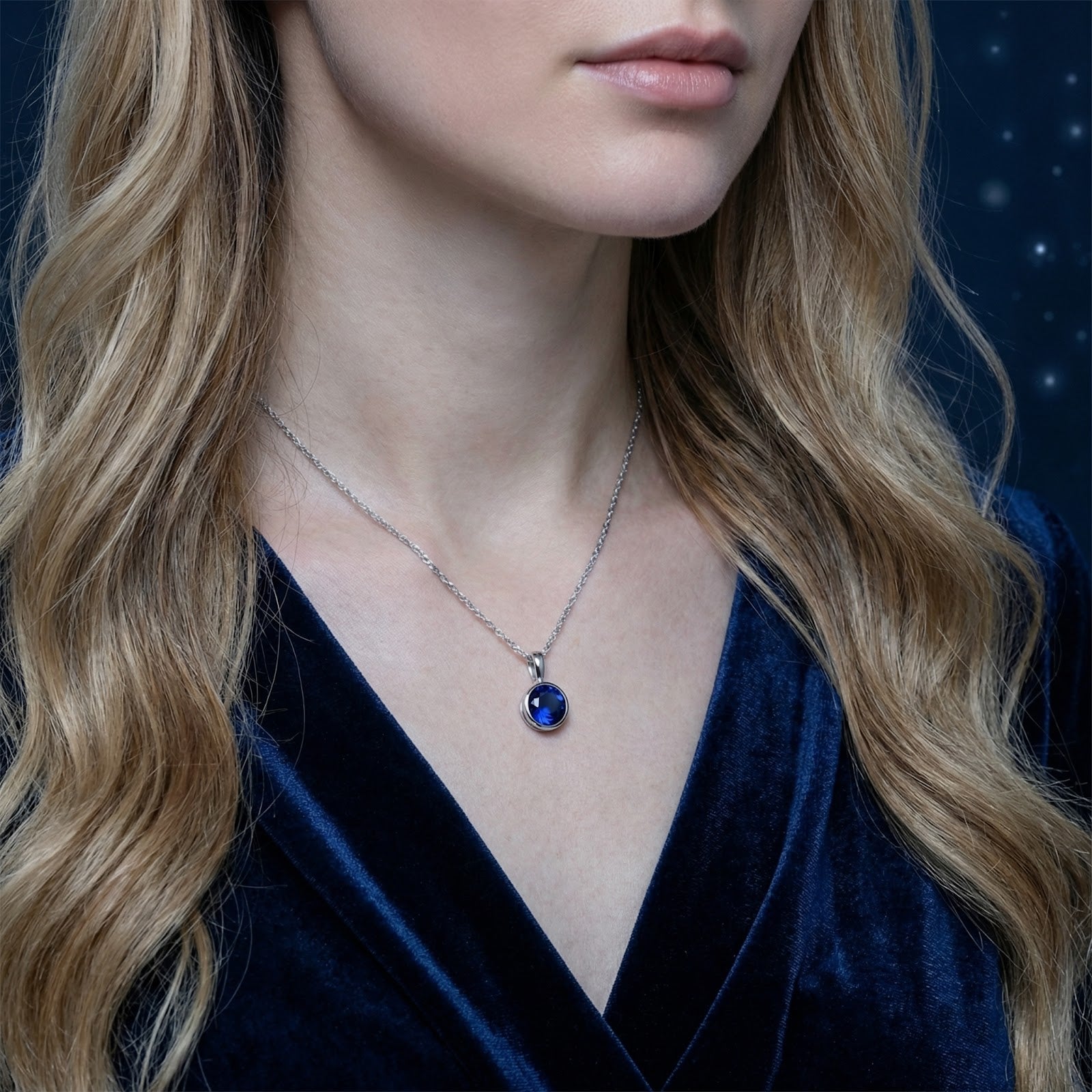 Model wearing the Callisara silver bezel necklace with a round simulated blue sapphire on a delicate chain.
