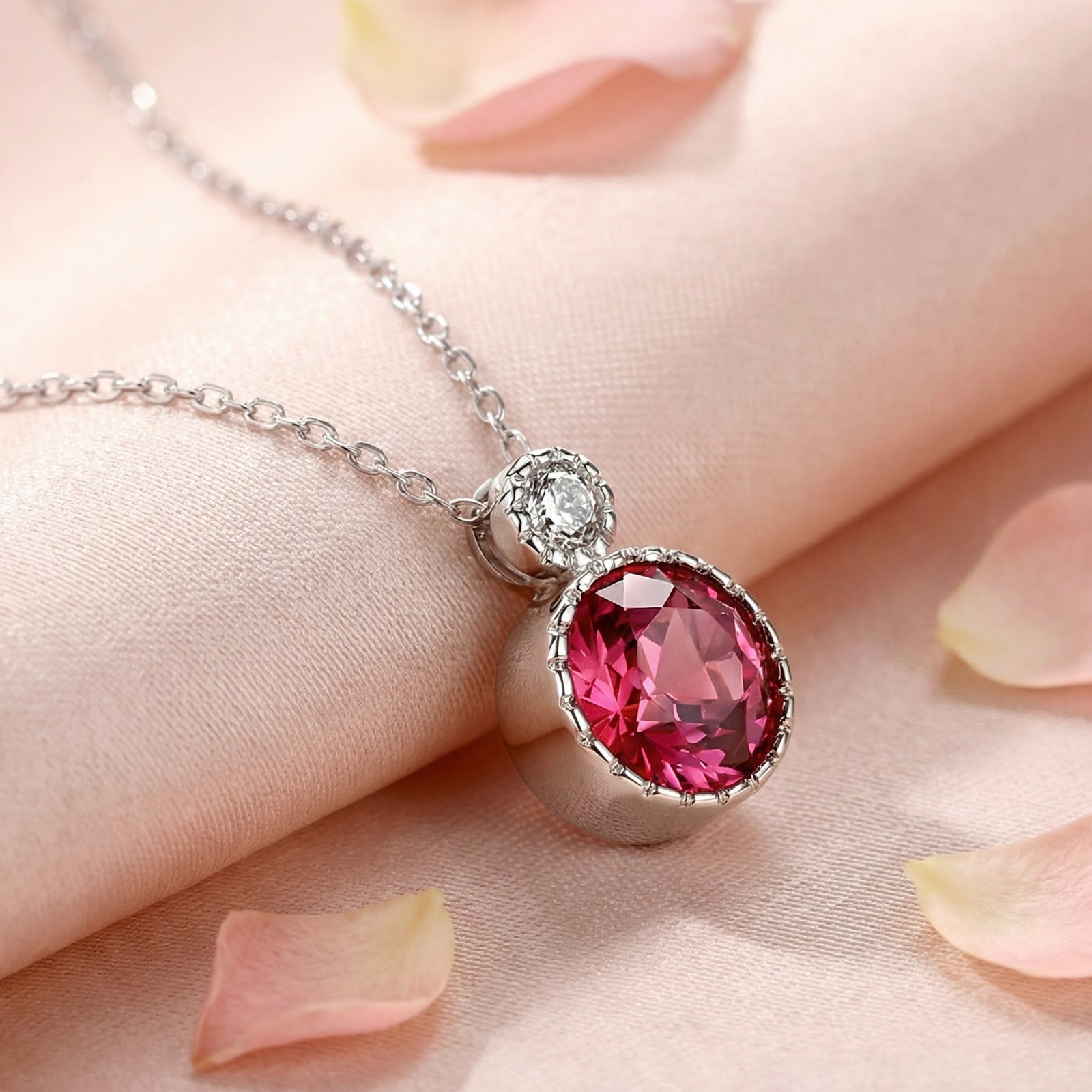 Front view of the round-cut simulated pink tourmaline pendant necklace in S925 sterling silver on pink fabric.