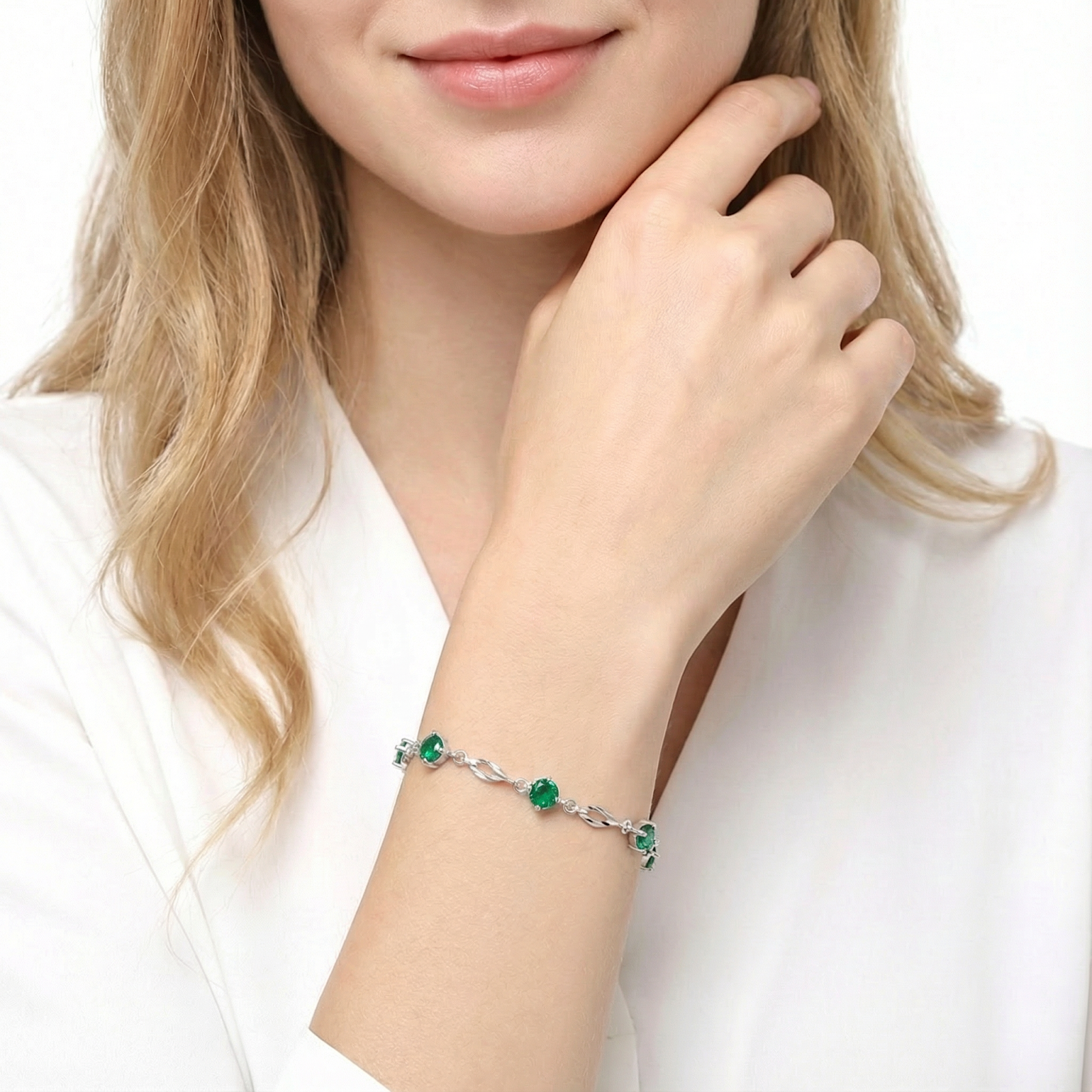 Woman wearing the sterling silver Aureliana station bracelet with round green simulated emeralds.