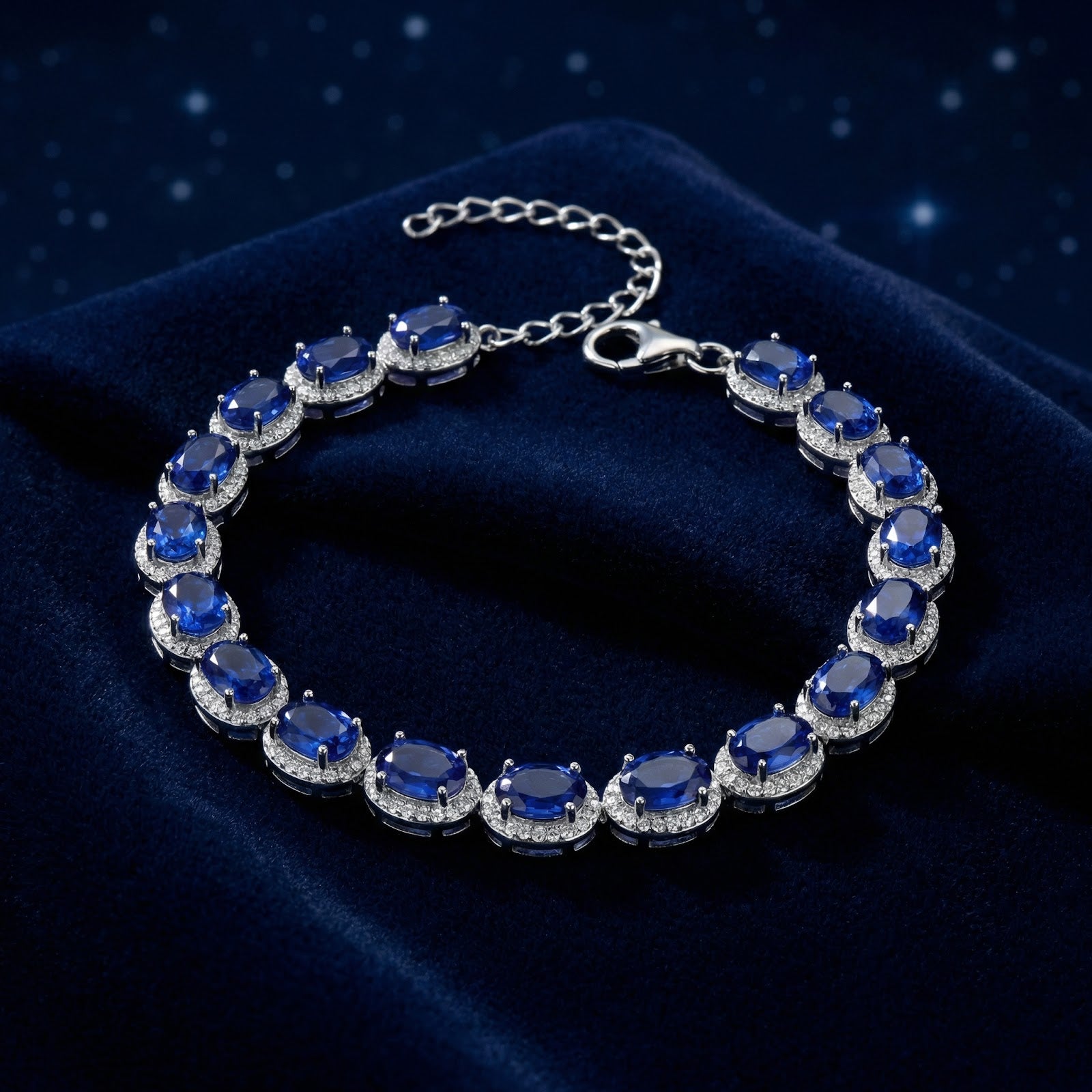 Oval-cut simulated sapphire halo bracelet in S925 sterling silver on a dark blue velvet background.