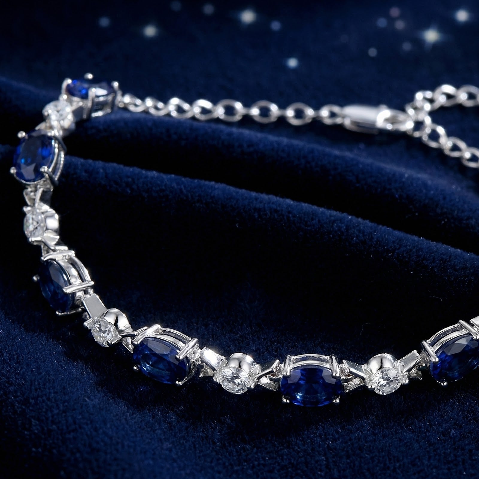 Close-up of oval-cut simulated blue sapphires and round white stones in a sterling silver tennis bracelet.