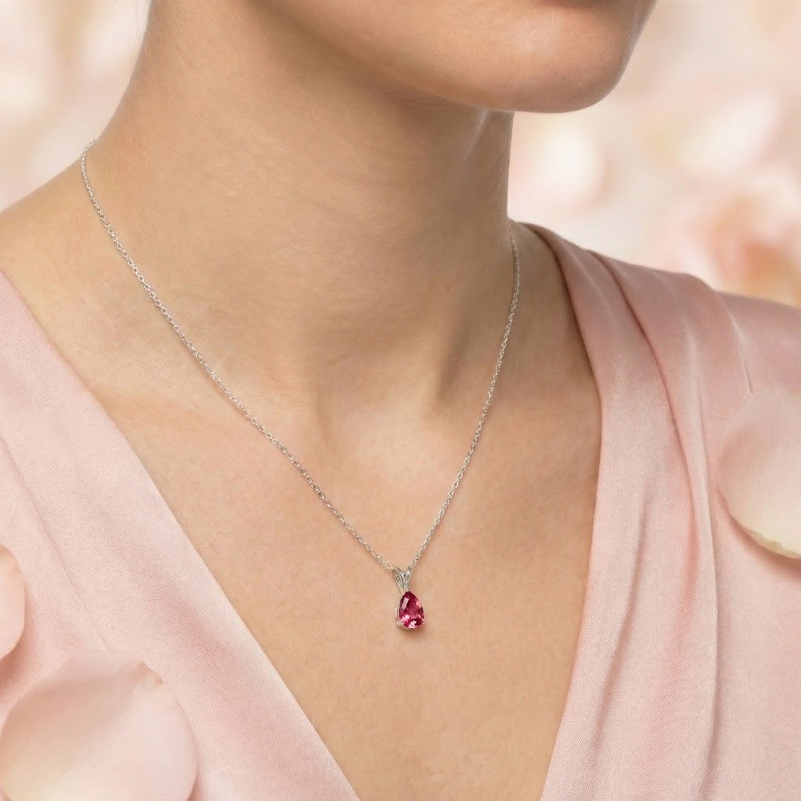 Sterling silver necklace with a pear-cut simulated pink tourmaline stone worn by a model.