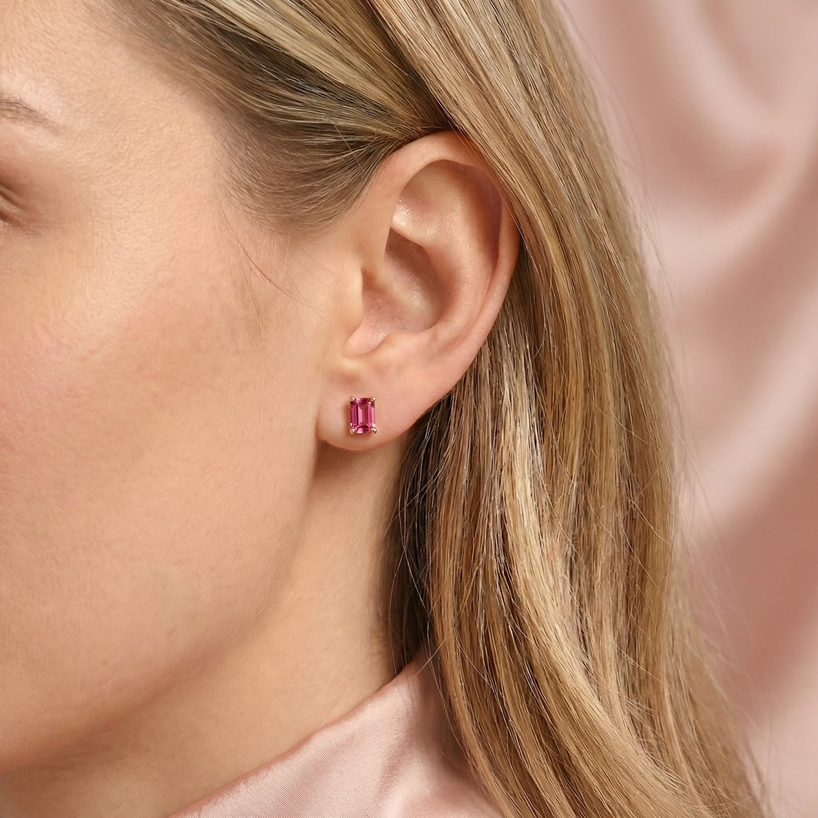 Side view of a model wearing the Iselise baguette-cut simulated pink tourmaline earring in 18K gold vermeil.
