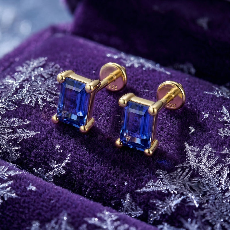 Close-up of emerald-cut simulated tanzanite earrings in 18K gold vermeil showing the S925 sterling silver hallmark.