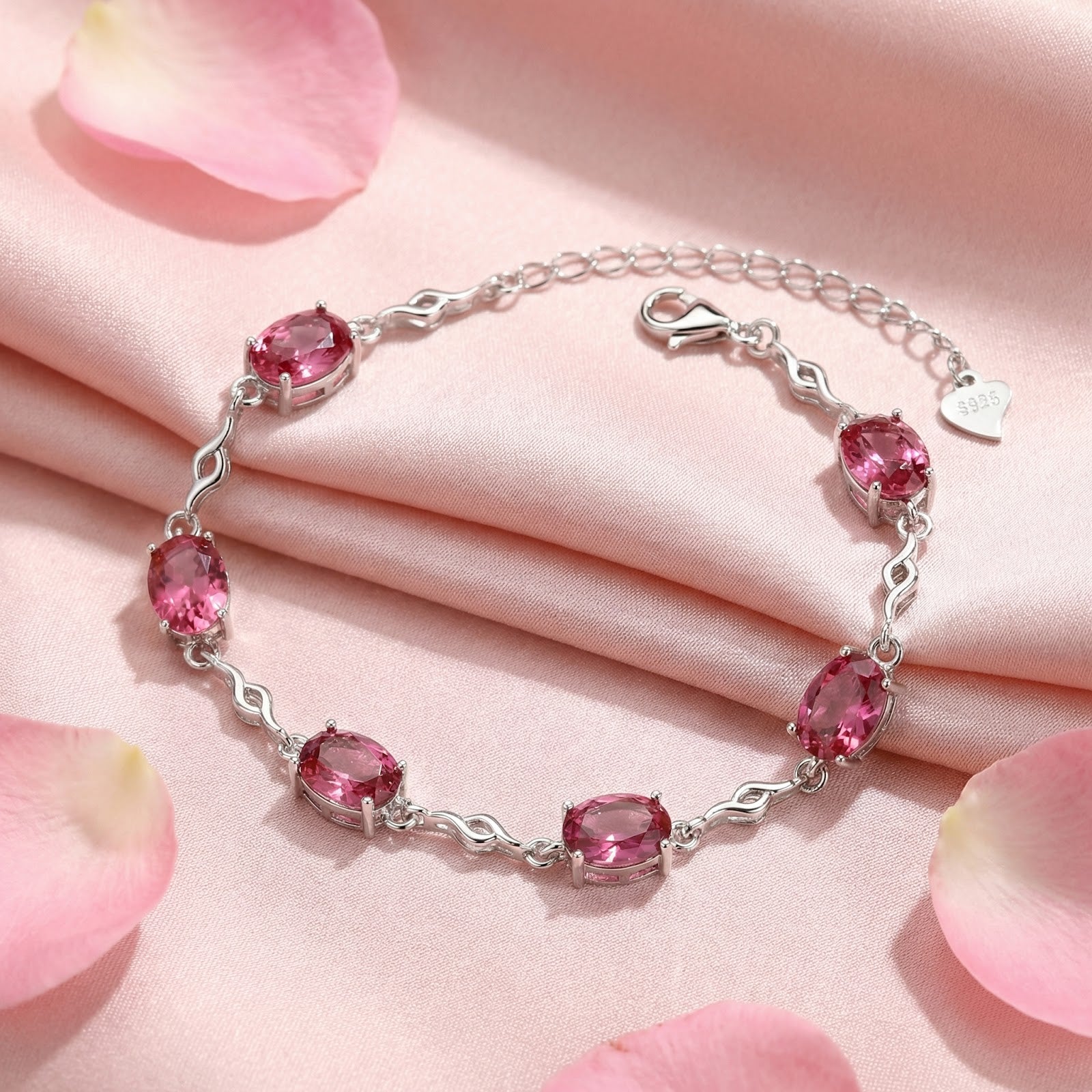 S925 sterling silver bracelet with oval pink tourmalines on pink silk fabric with rose petals.