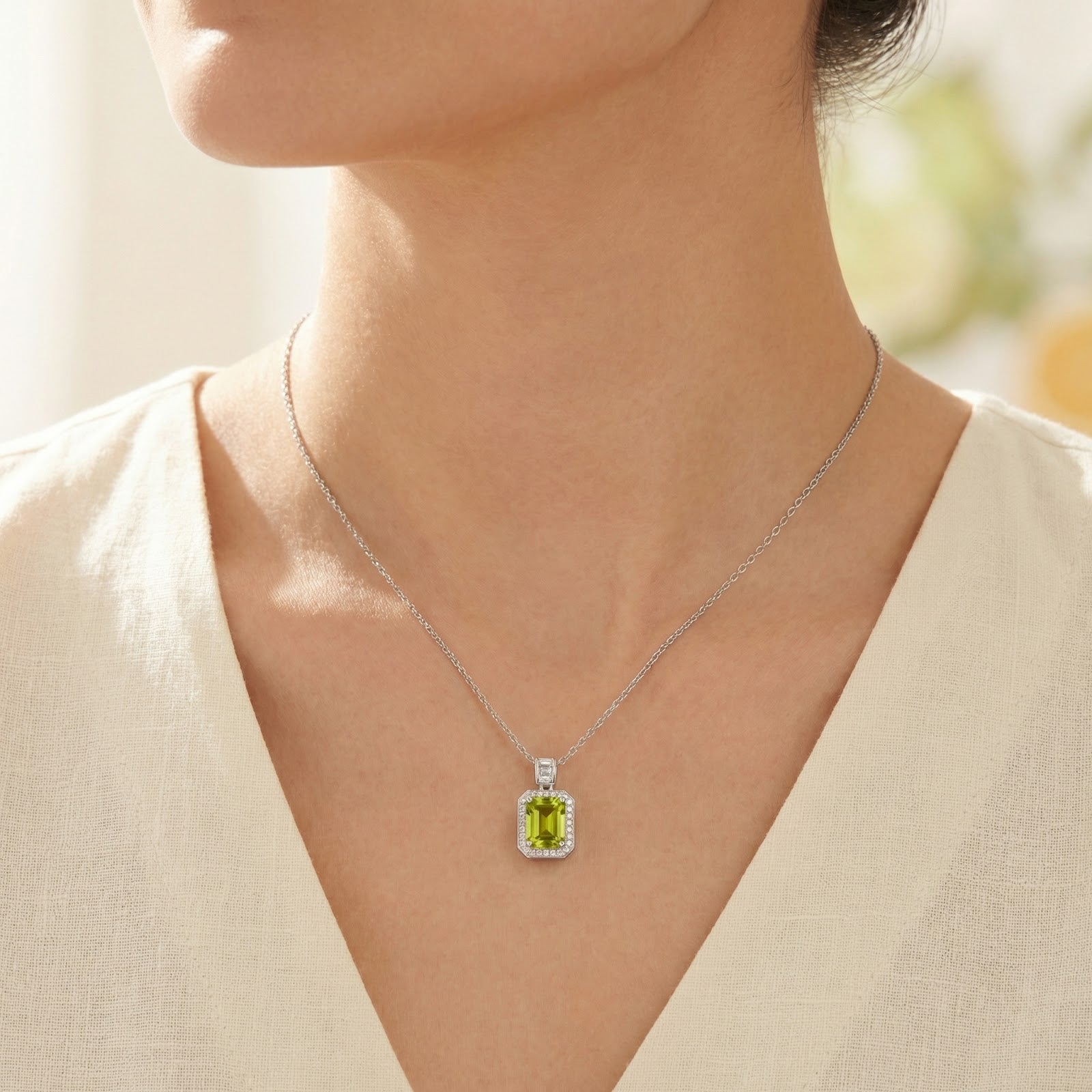 Close-up of a woman wearing the Elianara emerald-cut simulated peridot necklace in sterling silver.