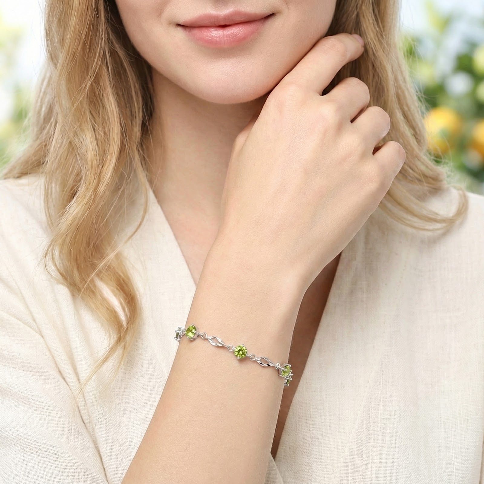 Woman wearing the Clarisse station bracelet in S925 sterling silver with vibrant green simulated peridot stones.