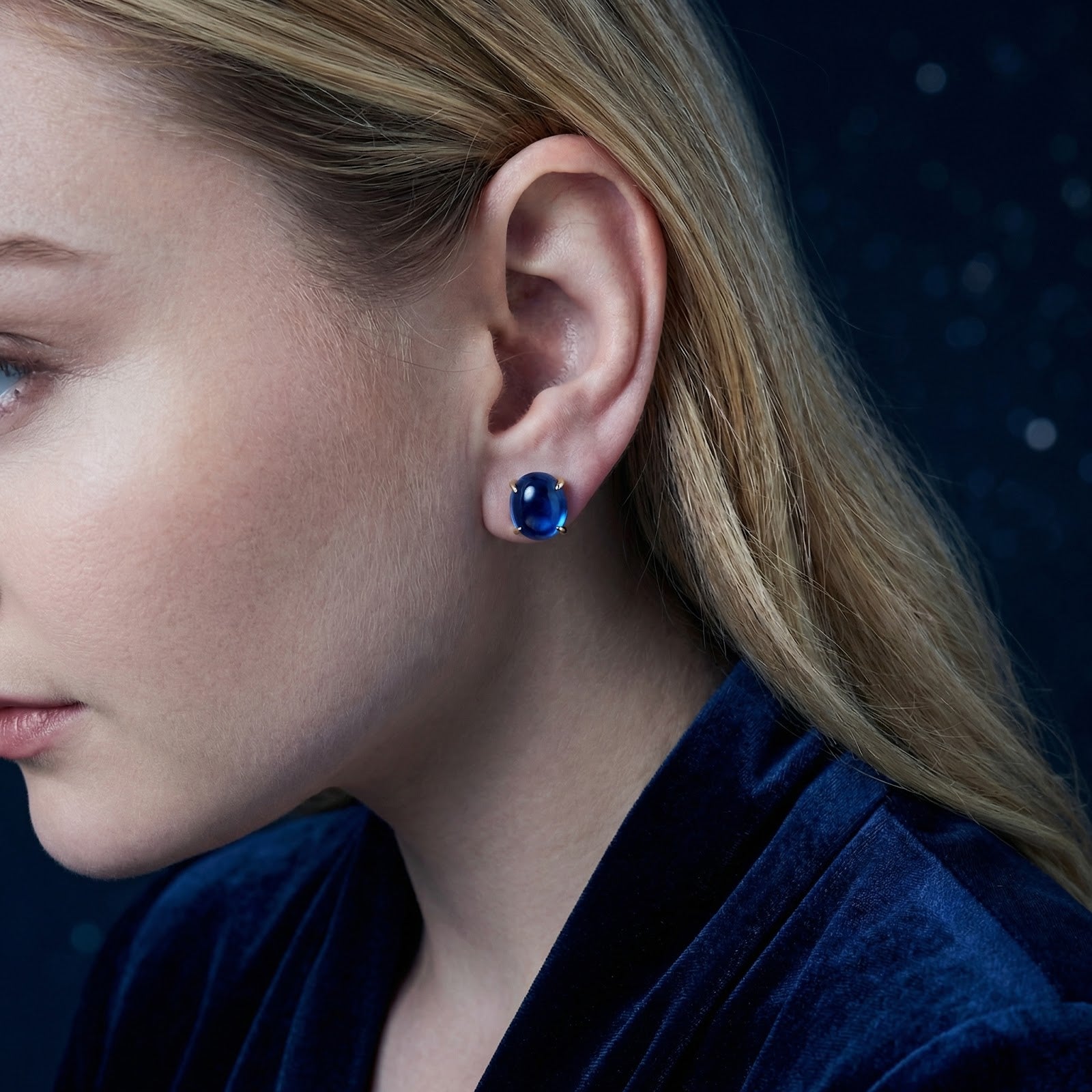 Side profile of a model wearing the Azurene 18K gold vermeil stud with a blue simulated sapphire.