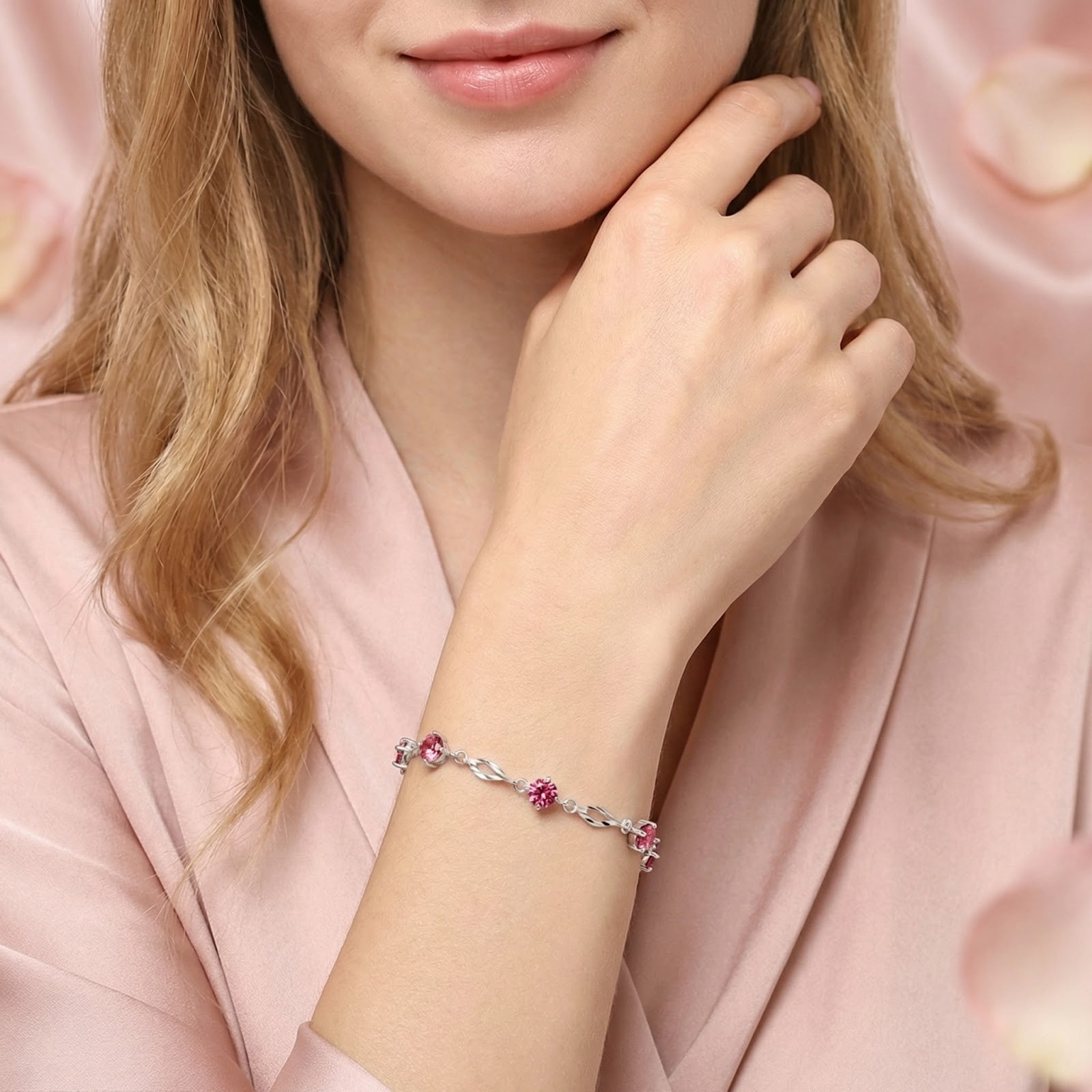 Woman wearing the Alizara sterling silver station bracelet with pink tourmaline stones on her wrist.