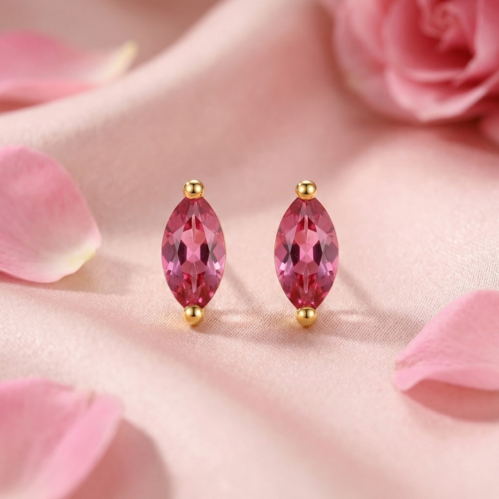 Detailed front view of marquise-cut pink tourmaline stud earrings in 18K gold vermeil on pink fabric.
