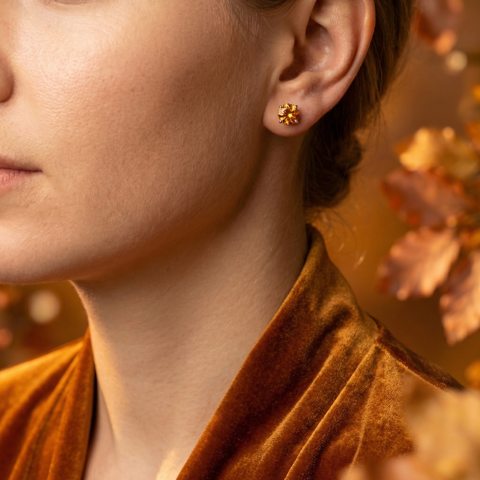 Model wearing a round cut simulated topaz stud earring in sterling silver, styled with a velvet dress.