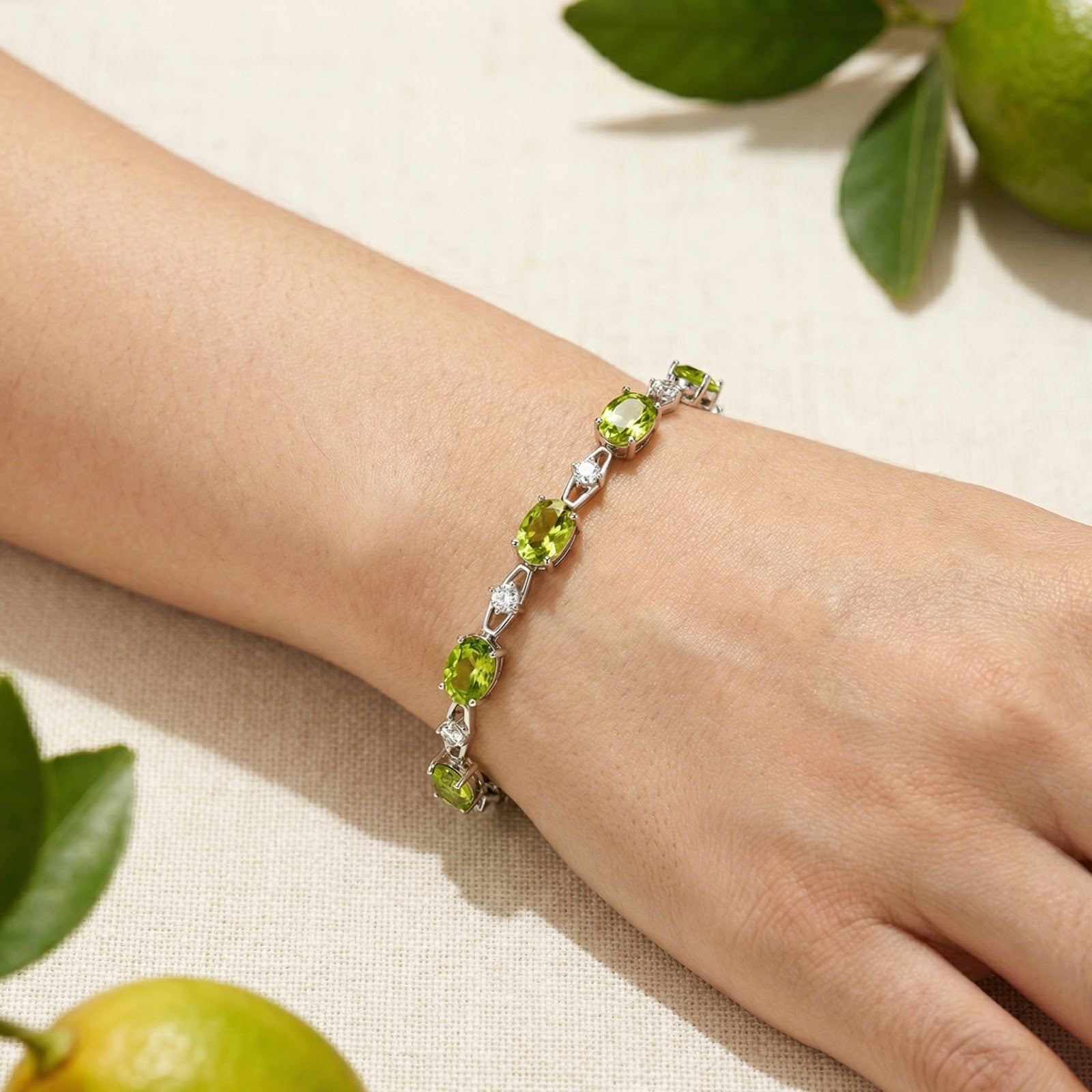 S925 sterling silver station bracelet with oval simulated peridot stones worn on a woman's wrist.