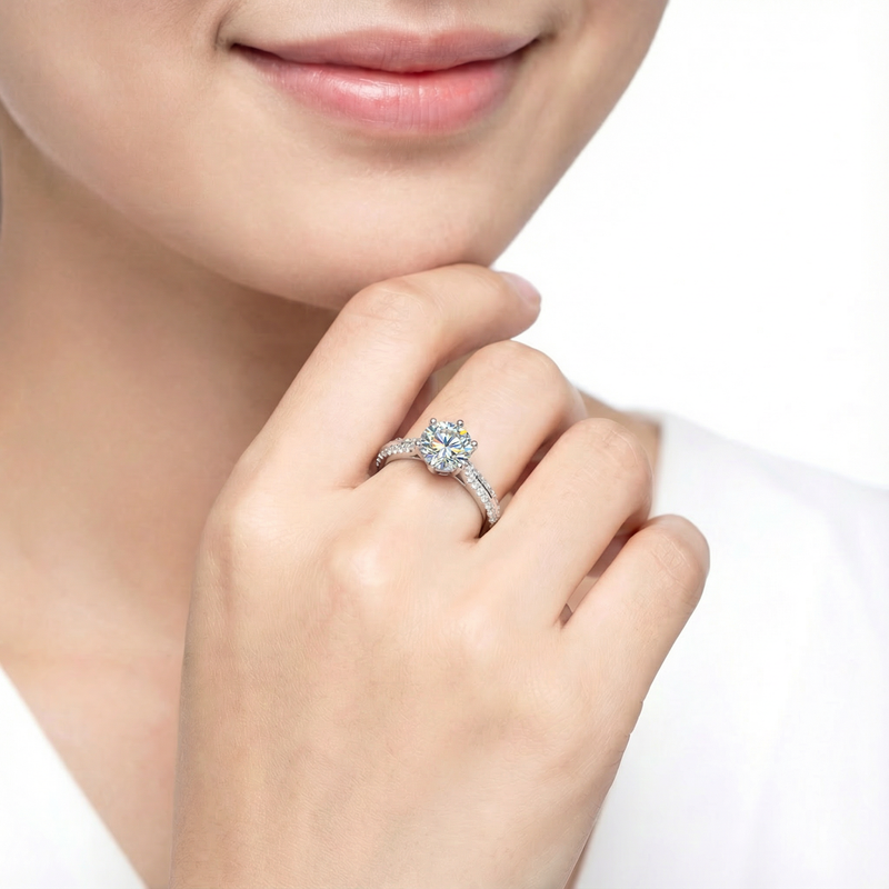 Woman wearing the Kalysta round simulated diamond solitaire ring in sterling silver on her finger.