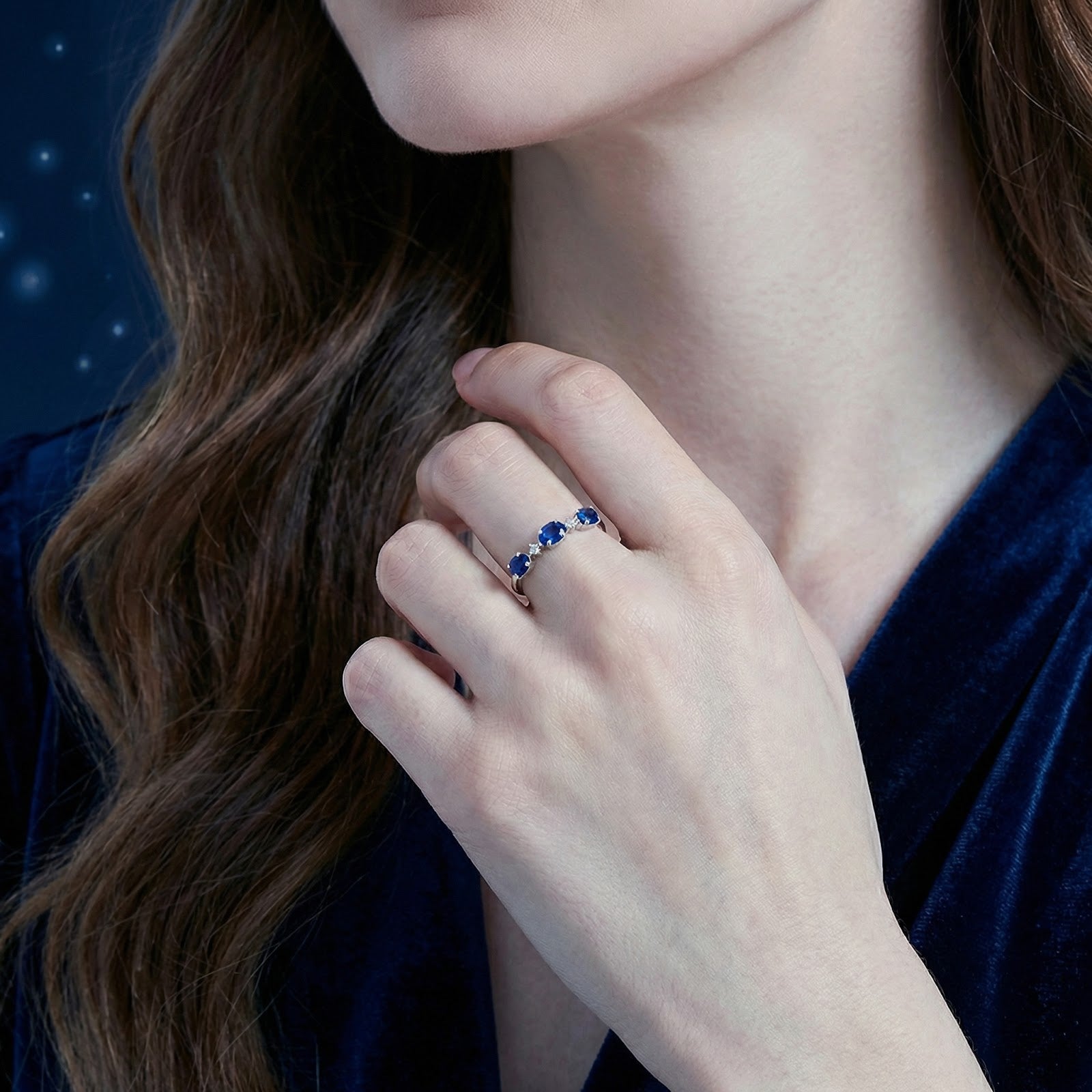Model wearing the Nerisara S925 sterling silver bypass ring with blue sapphires on her finger.