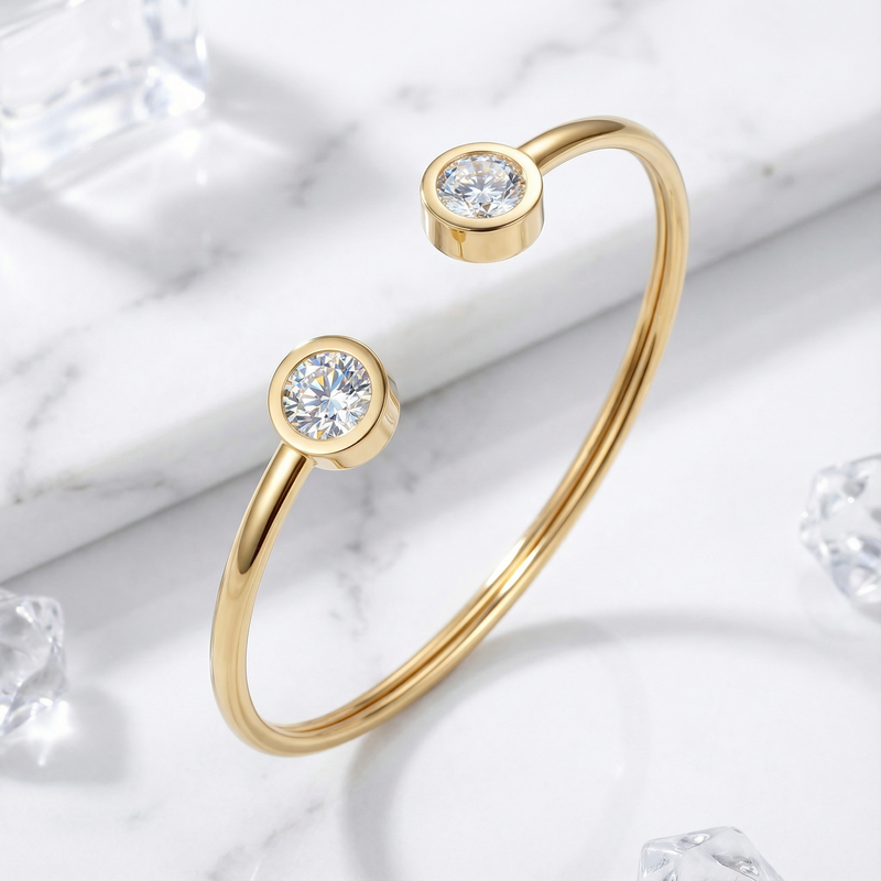 Gold stainless steel cuff bracelet with round-cut simulated diamonds on a marble surface with ice cubes.