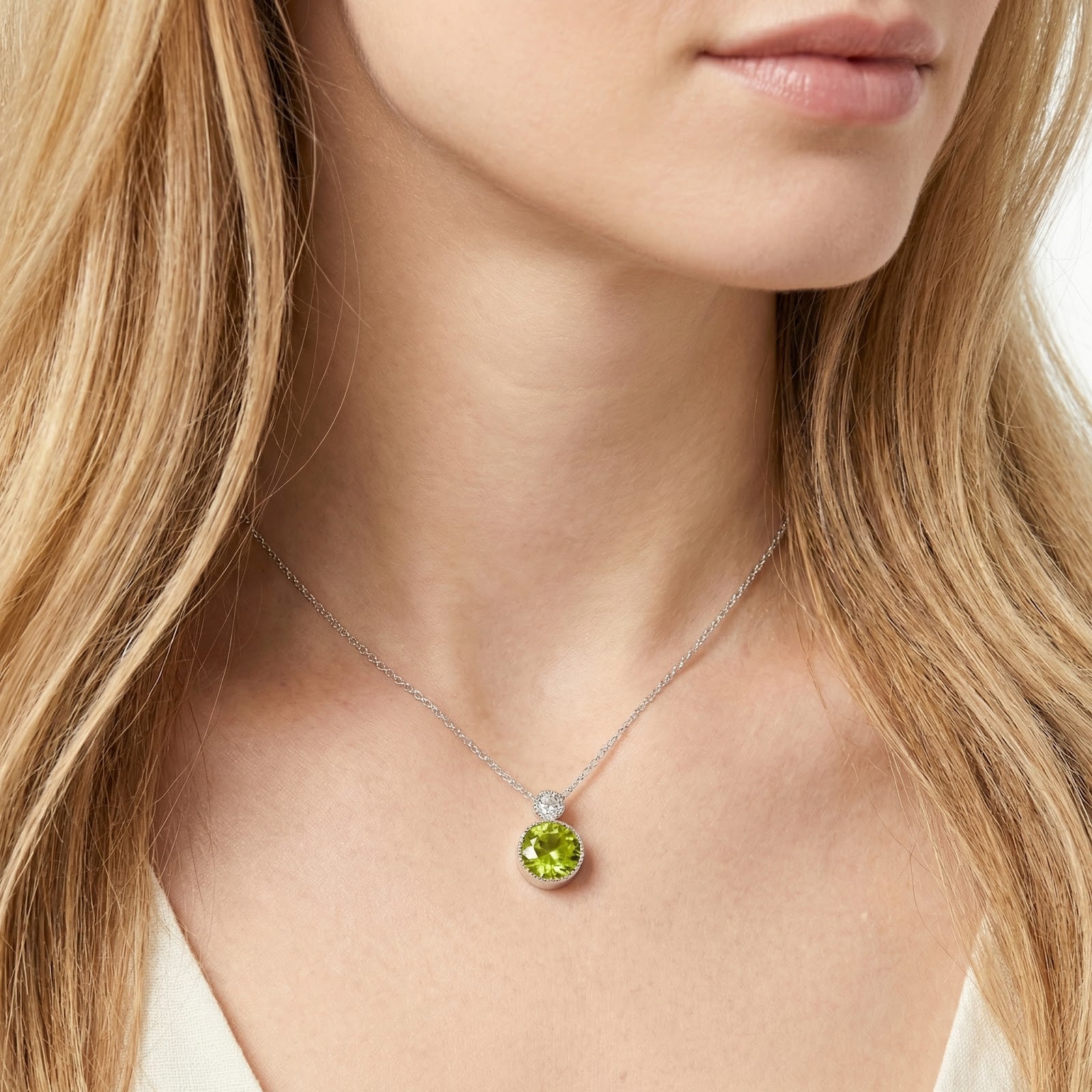 Model wearing the silver round-cut simulated peridot necklace, showing the pendant's scale and vibrant green color.