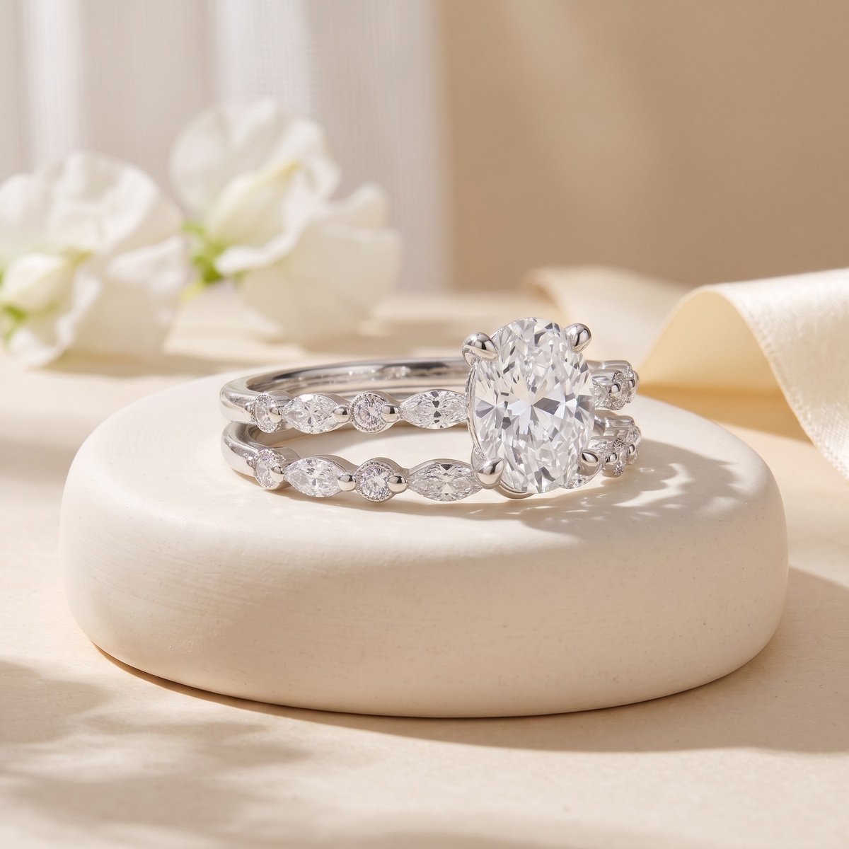 Oval moissanite two-piece ring set in silver, angled close-up