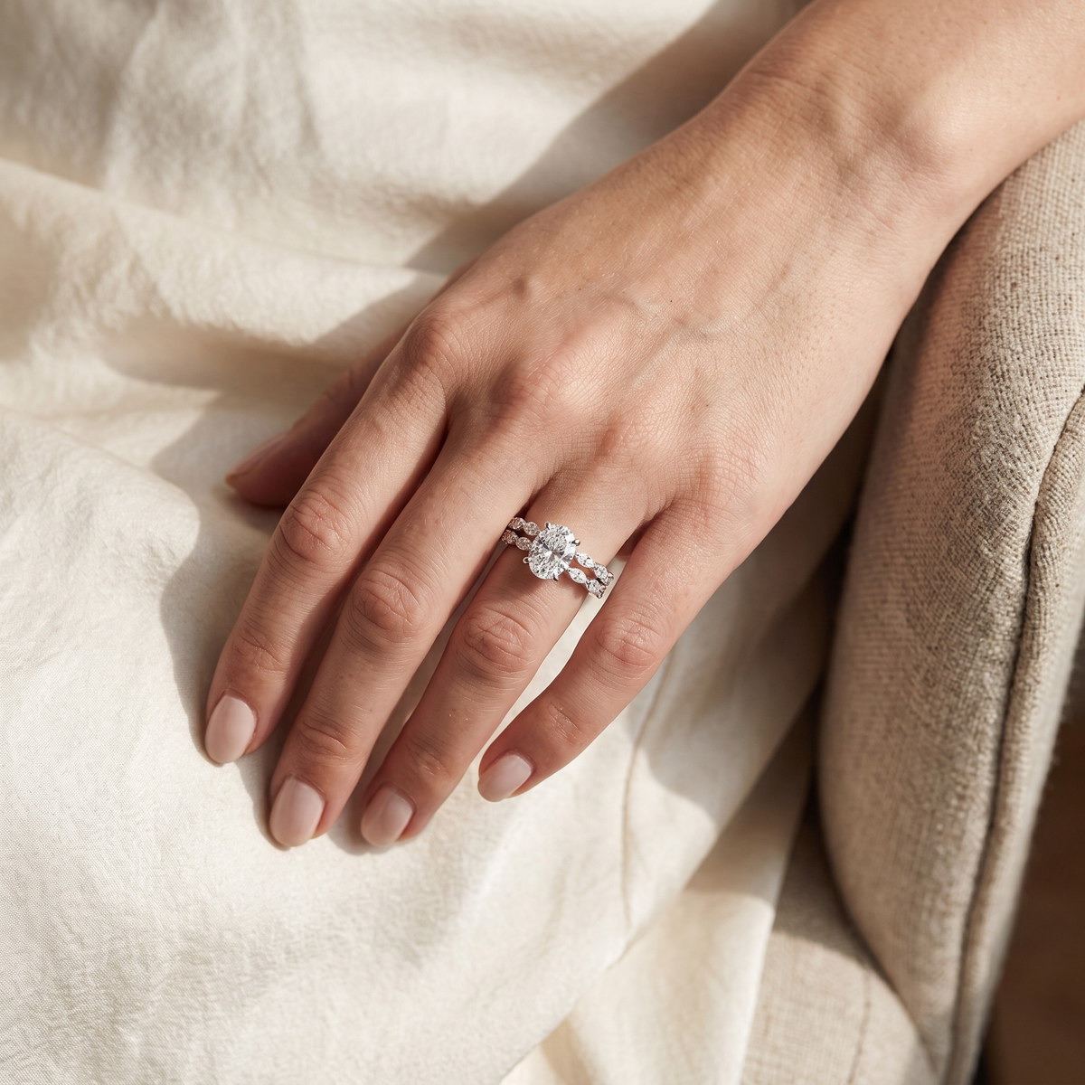 Oval moissanite two-piece ring set in silver, worn on a model's hand