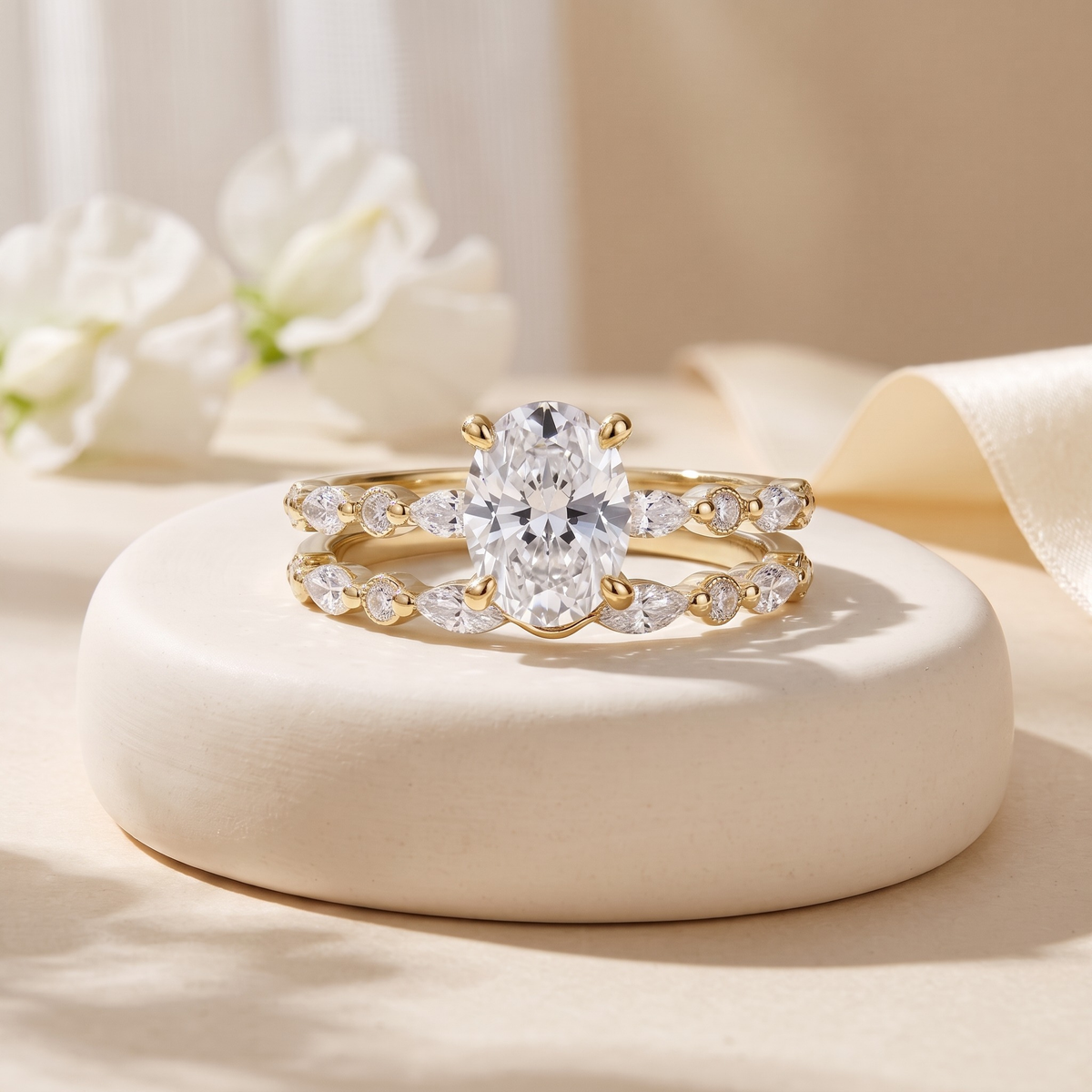 Oval moissanite two-piece ring set in yellow gold, isolated front view